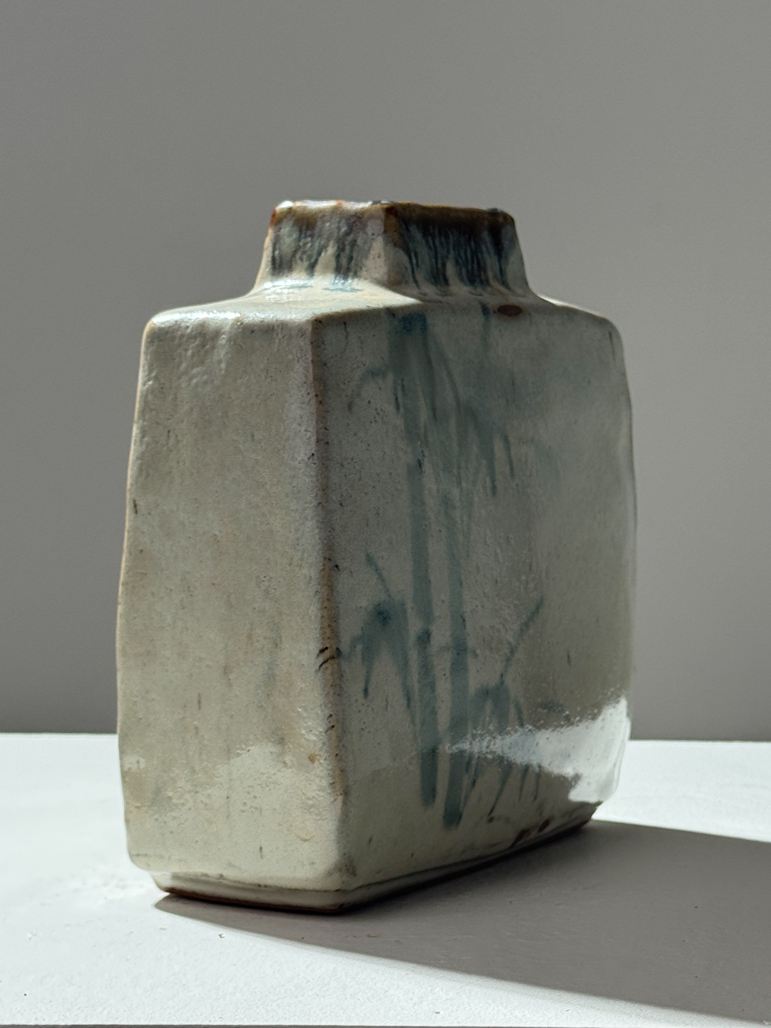 Handcrafted ceramic vase with blue-green glaze drip detail