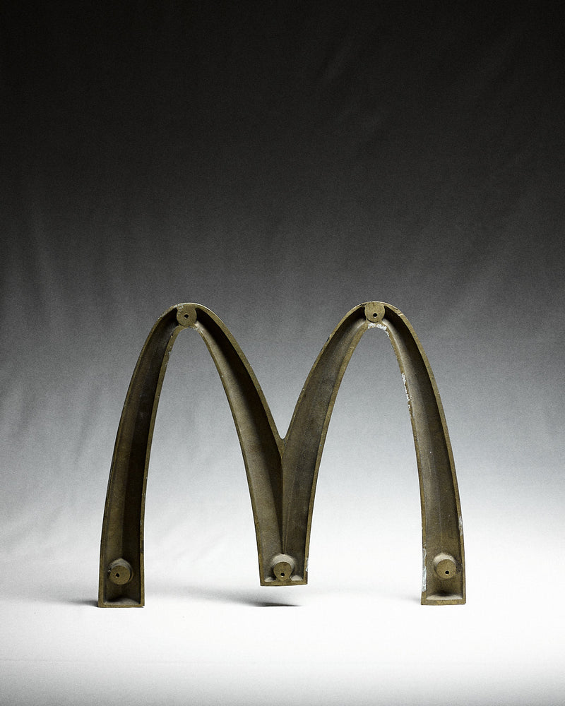 Vintage Italian McDonalds Sign in Brass — close-up of brass letter M