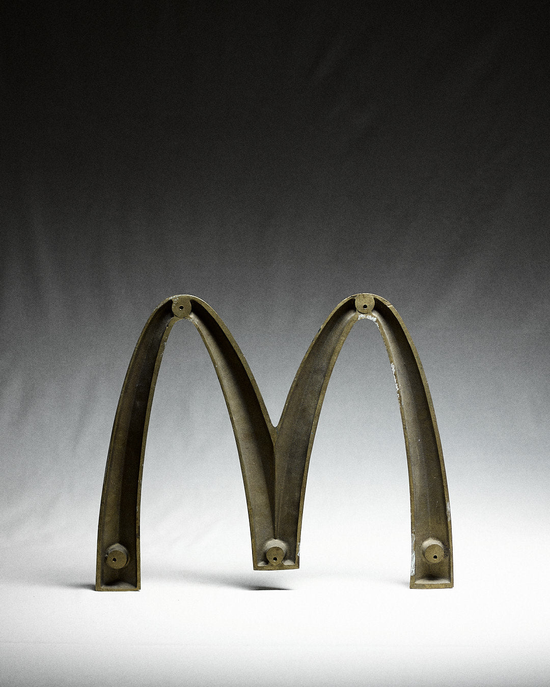 Vintage Italian McDonalds Sign in Brass — close-up of brass letter M