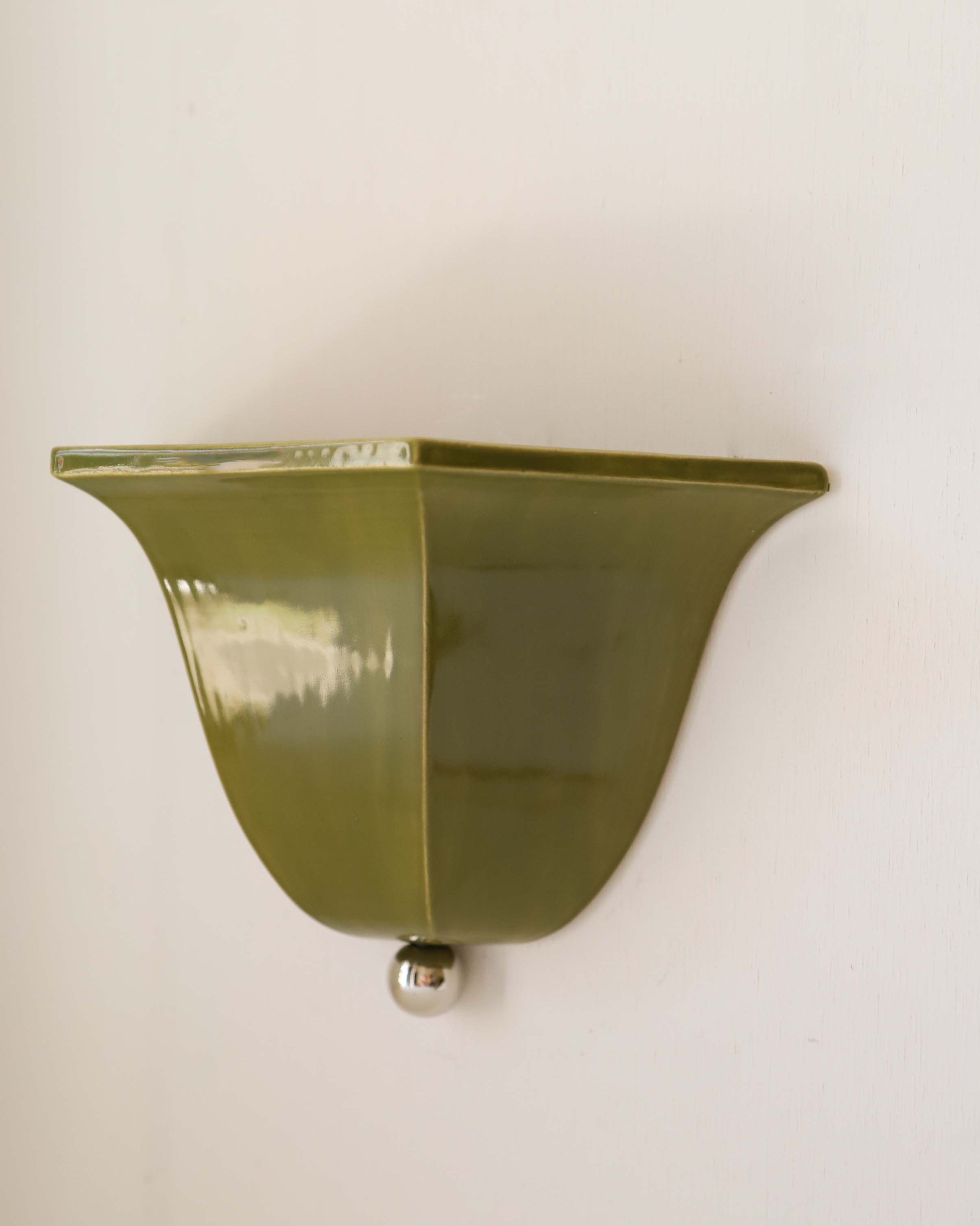 Maeve olive green glass wall sconce mounted on white wall