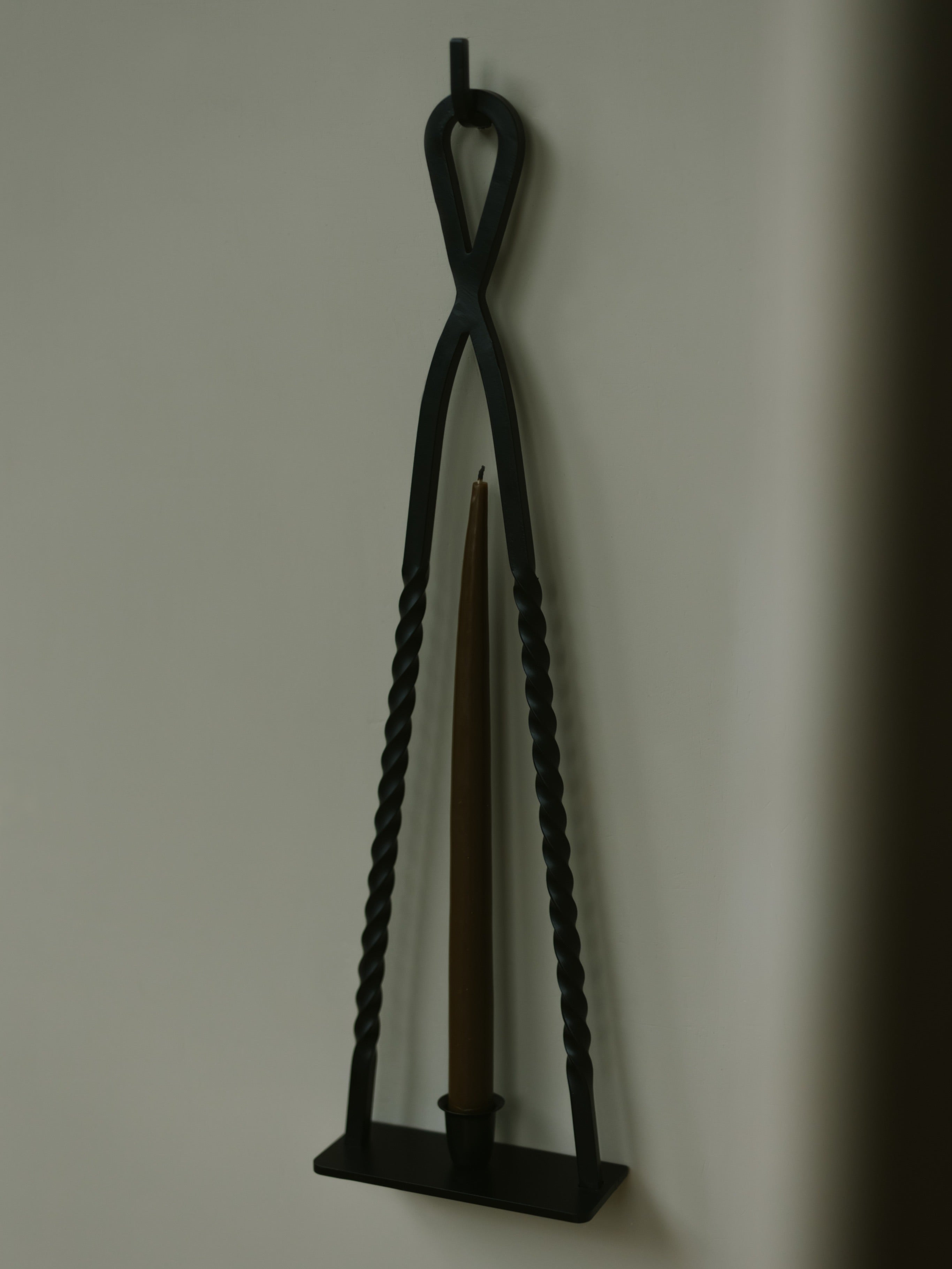 Alchemy Candle Holder — side angle with black metal design and candle