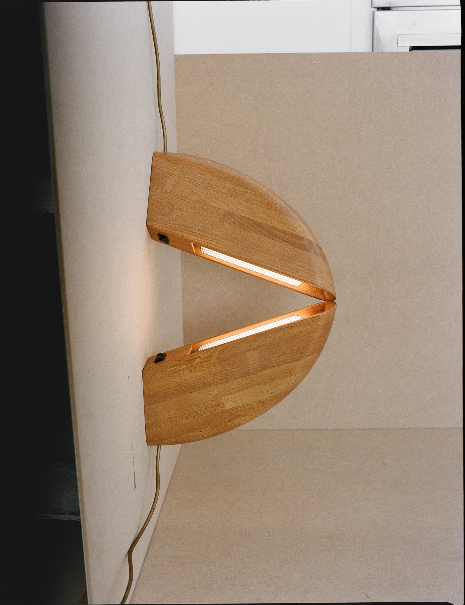 Set of 2 Vintage French Artisanal Table Lamps in Solid Oak Wood C. 1980 — close-up of wooden lamp body with light on