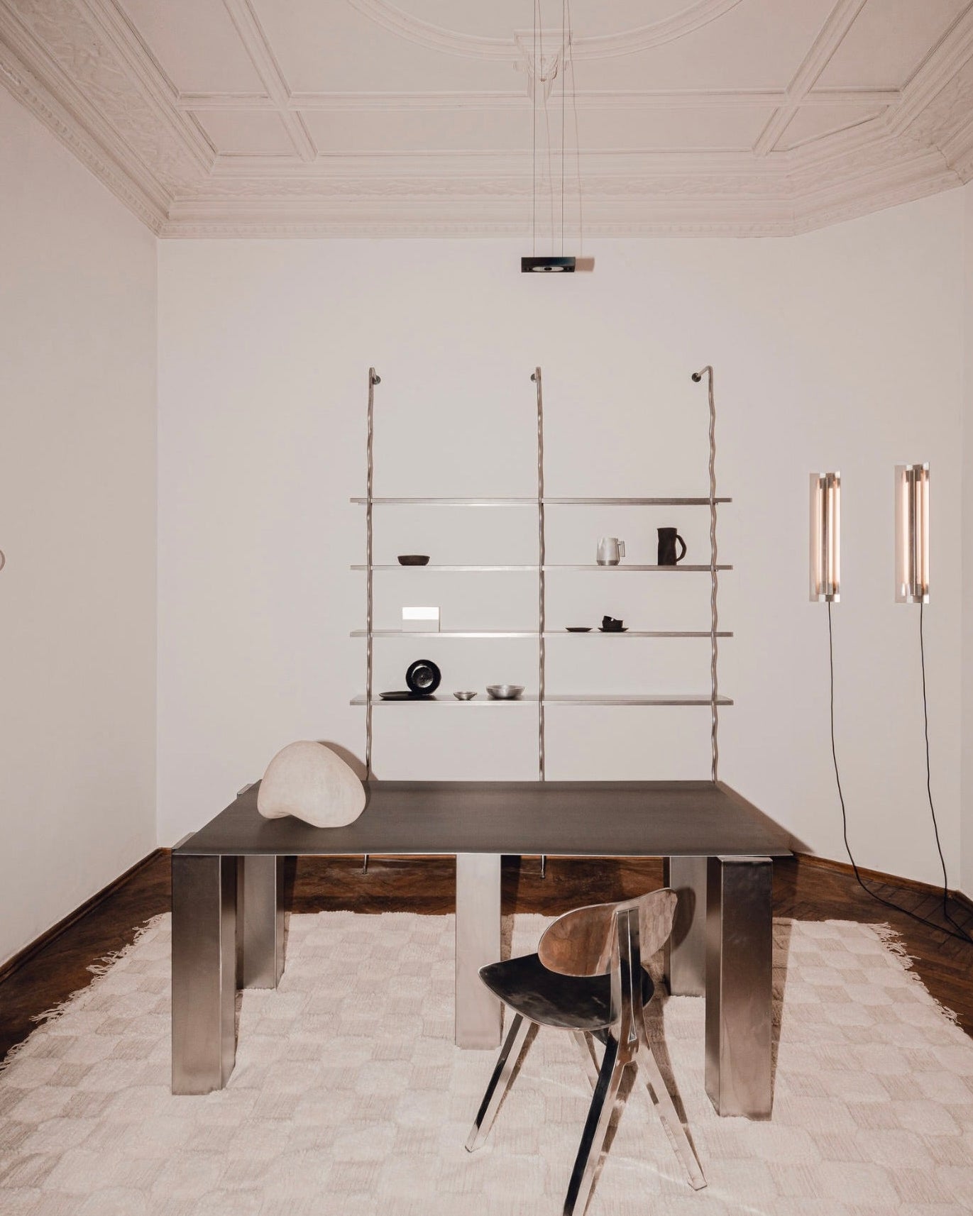 Modern wall-mounted shelving system with ceramic objects in minimalist dining room