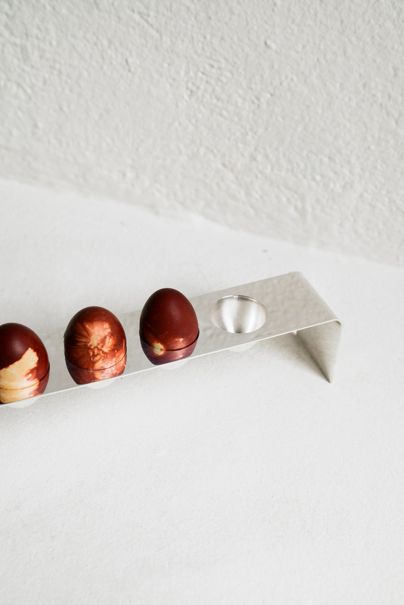 Minimalist Silver Tableware — close-up of silver egg holder with decorative eggs