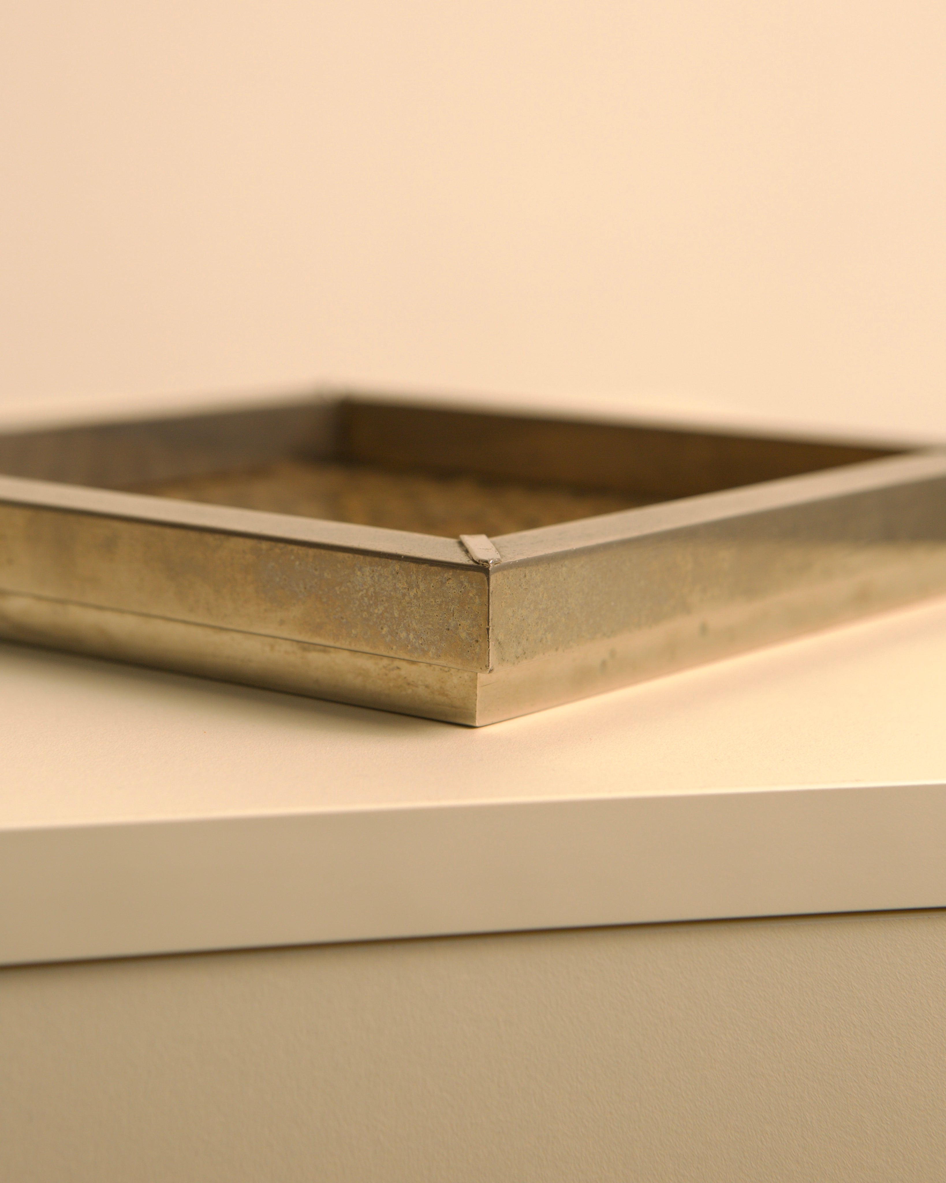 Golden square metal vide-poche detail showing refined edges, 1970s