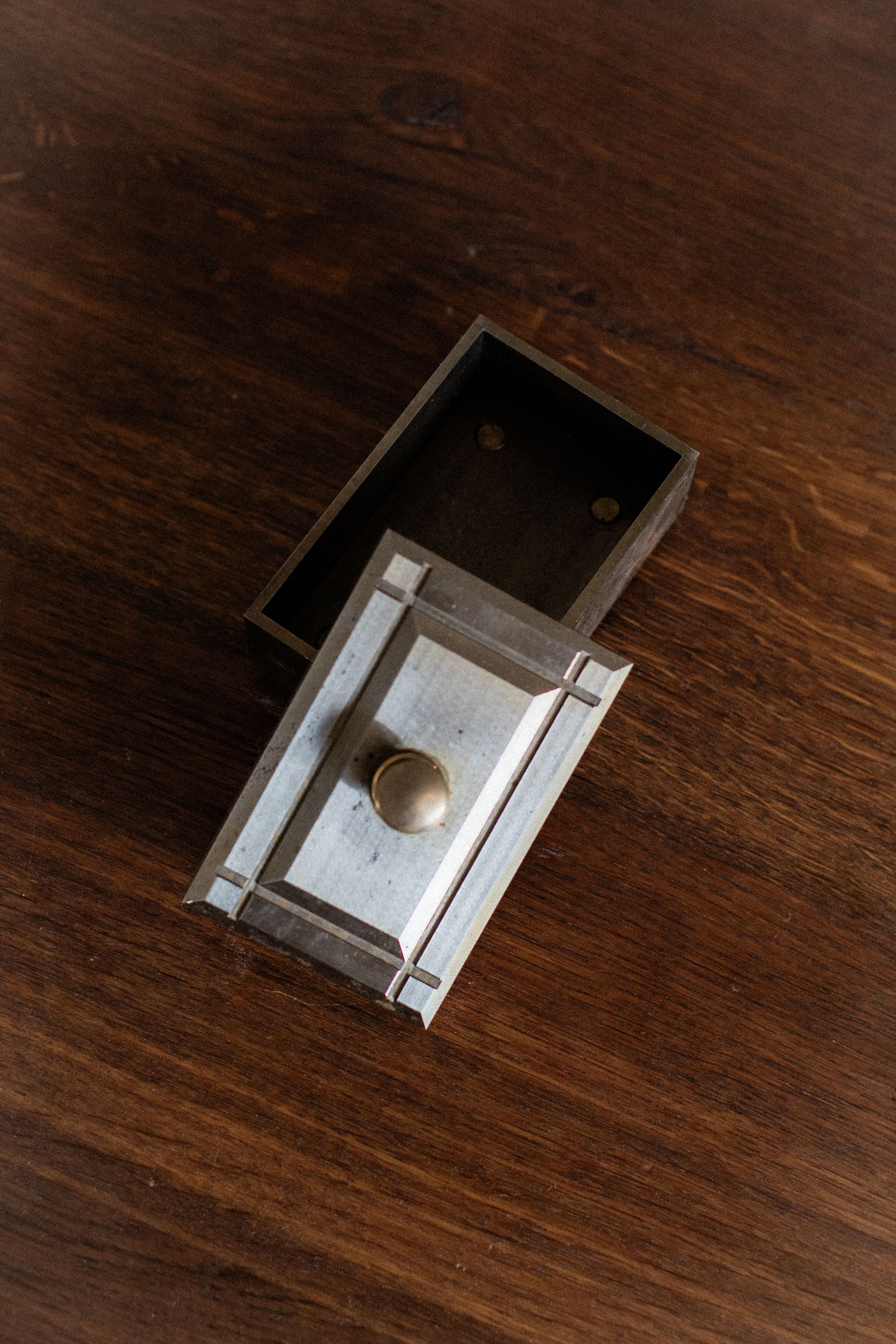 Industrial metal storage box with hinged lid and brass knob detail