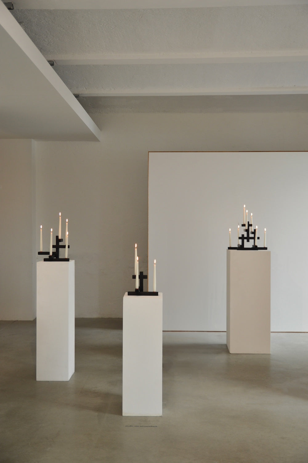 TETRIS 5 — black candle holders displayed on white pedestals