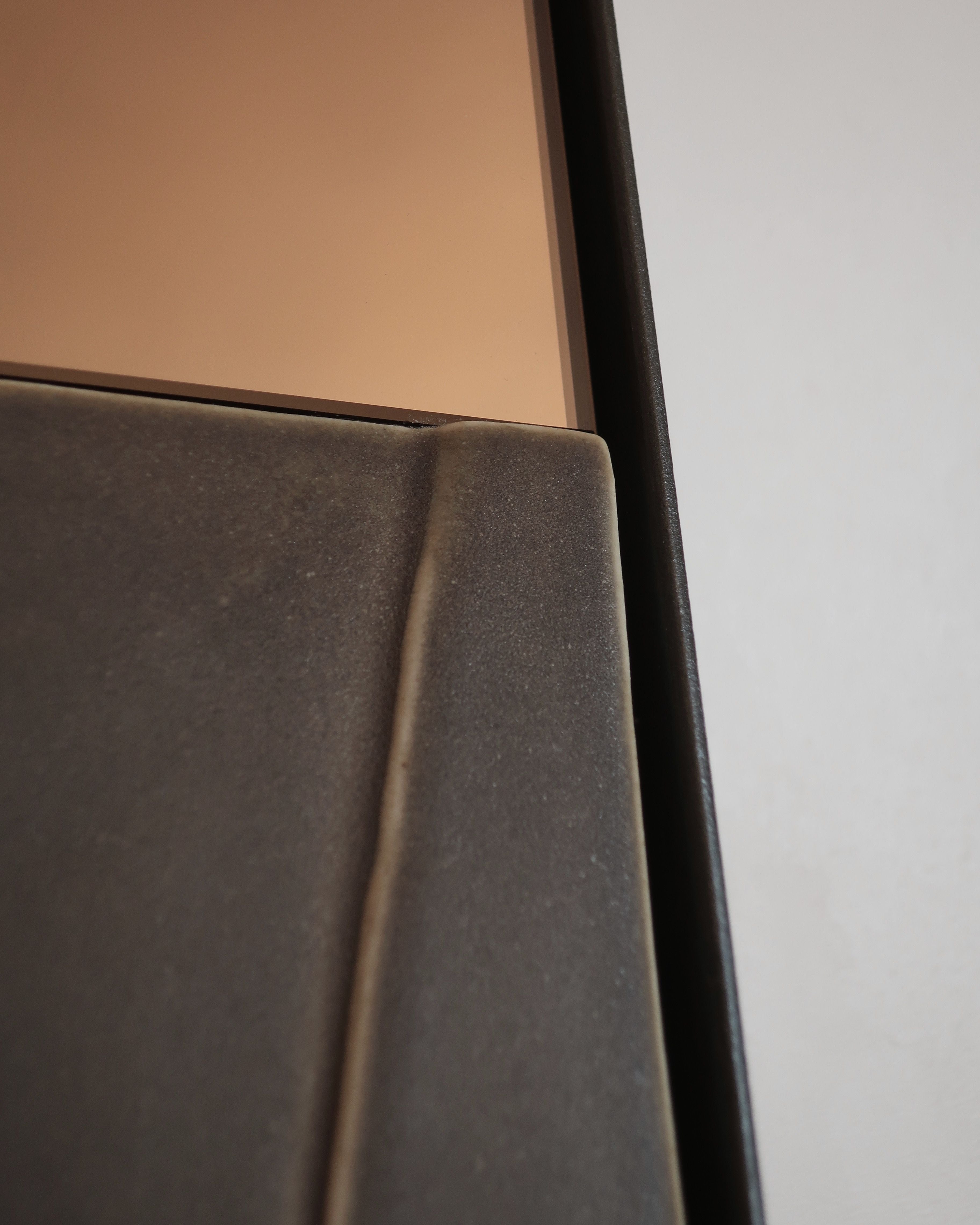 Close-up detail of GIO I mirror's curved metallic frame edge