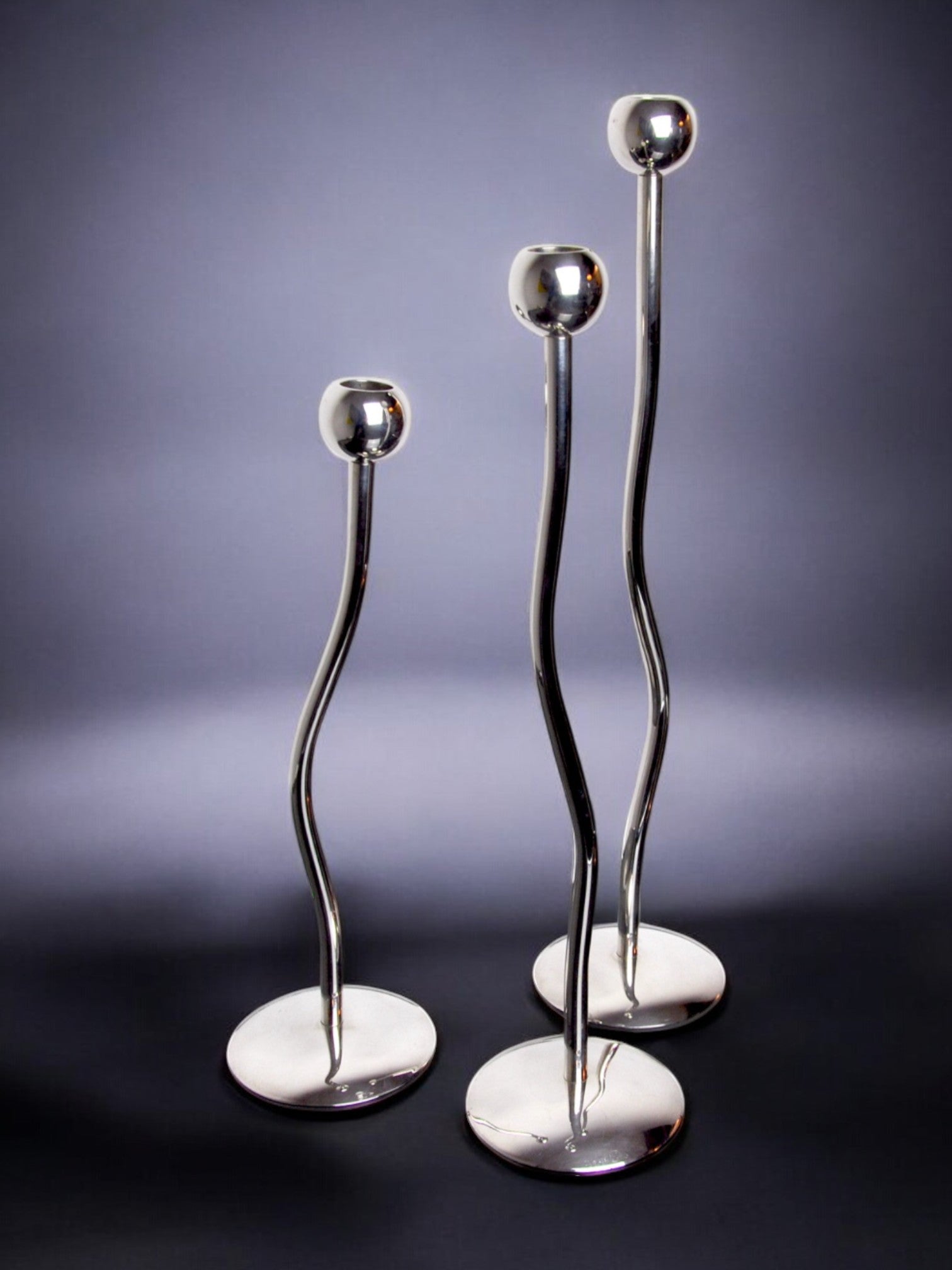 Trio of silver metal candlesticks from mesa italy, italy, 1980s — lifestyle setting