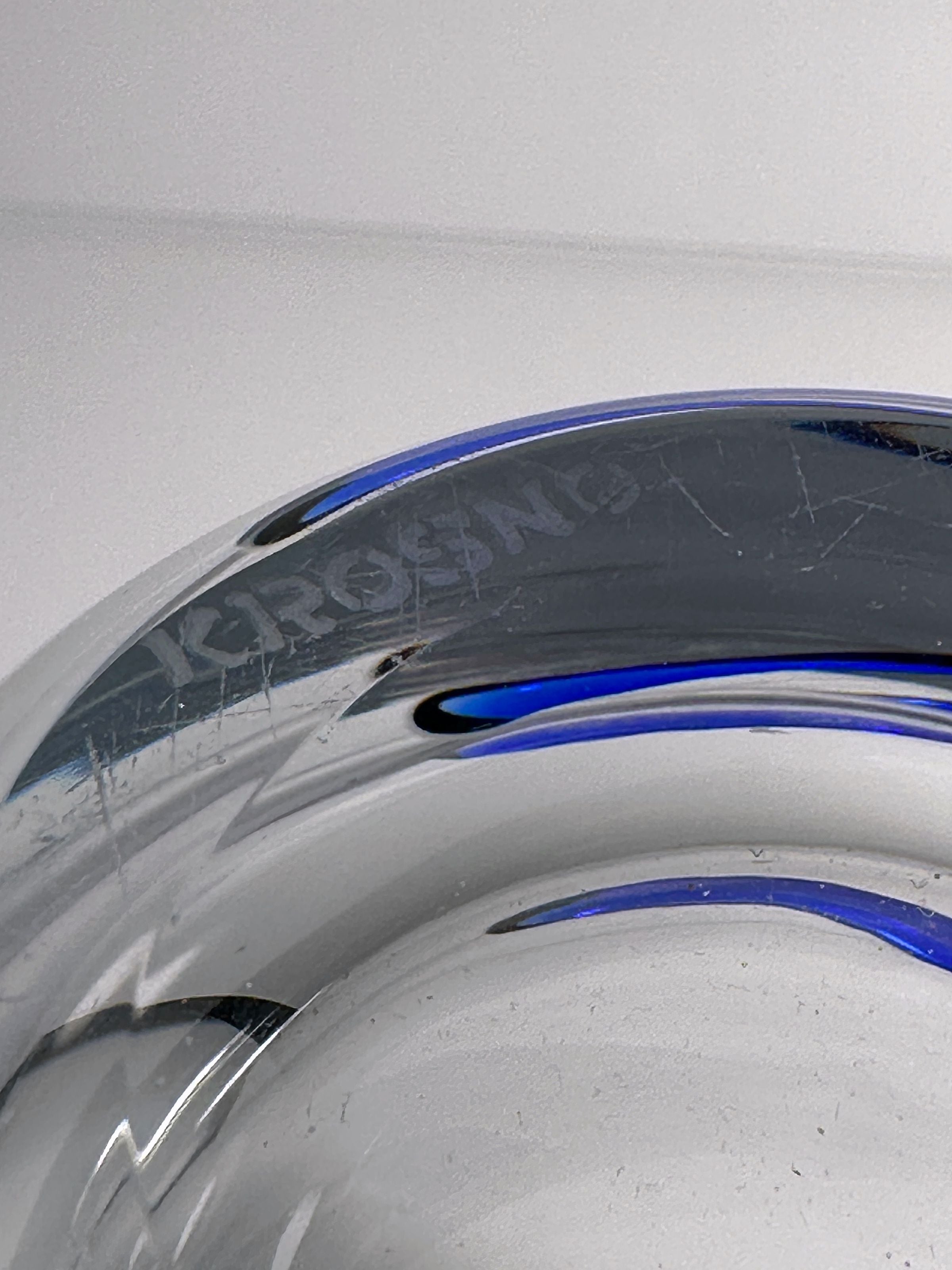 Crystal glass vase detail showing curved sculptural form with blue accents