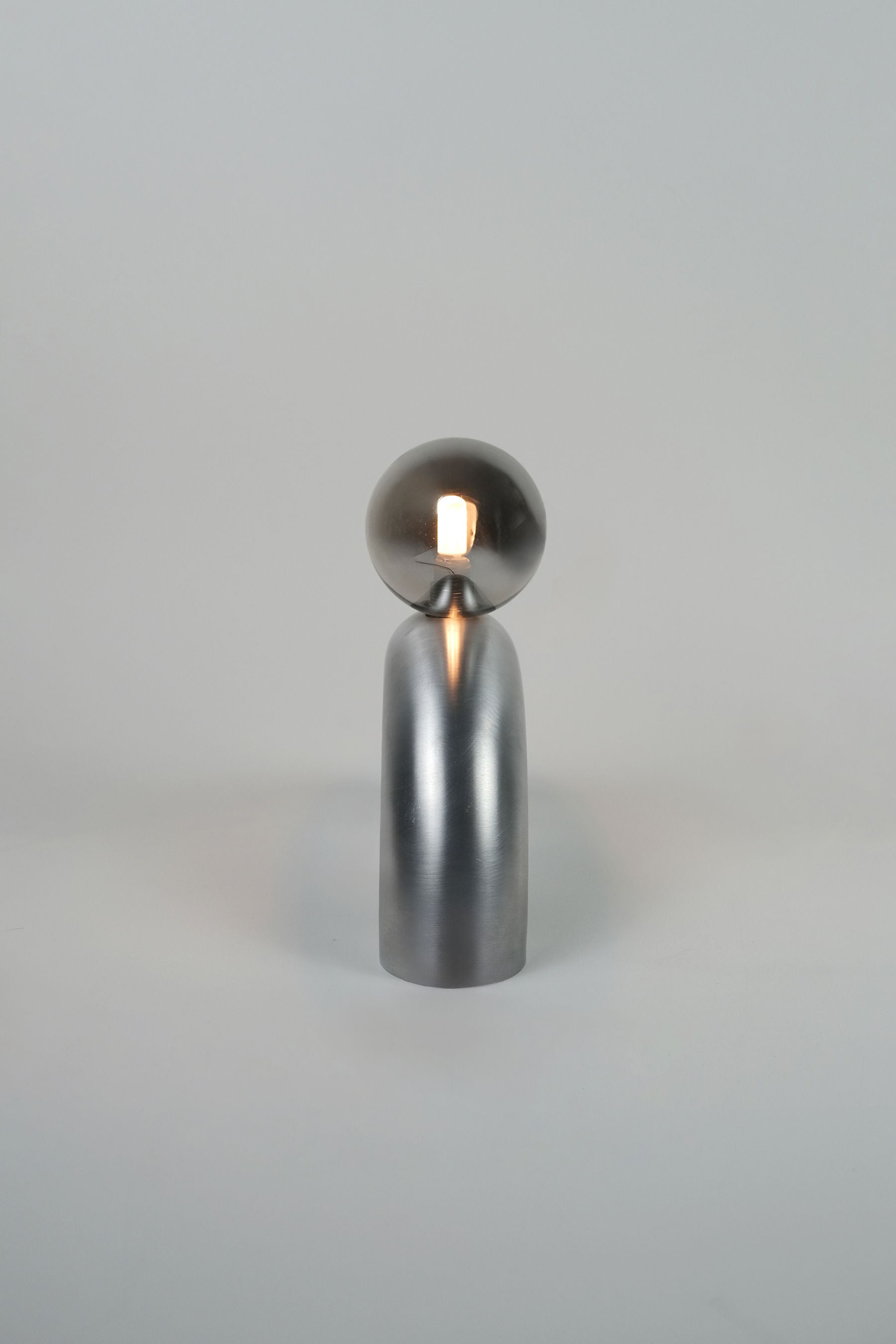 Aluminum arc table lamp with spherical shade and cylindrical base