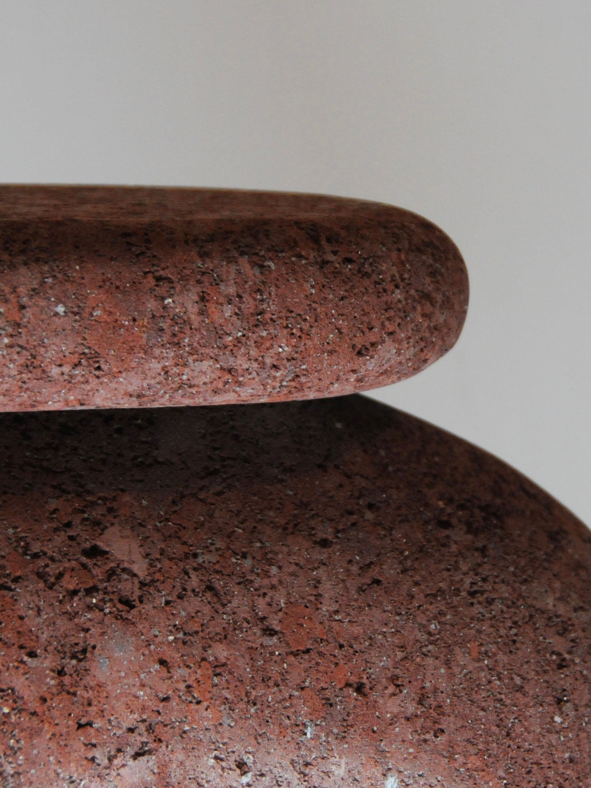 Neolithic' Stool — close-up of textured reddish-brown stone surface