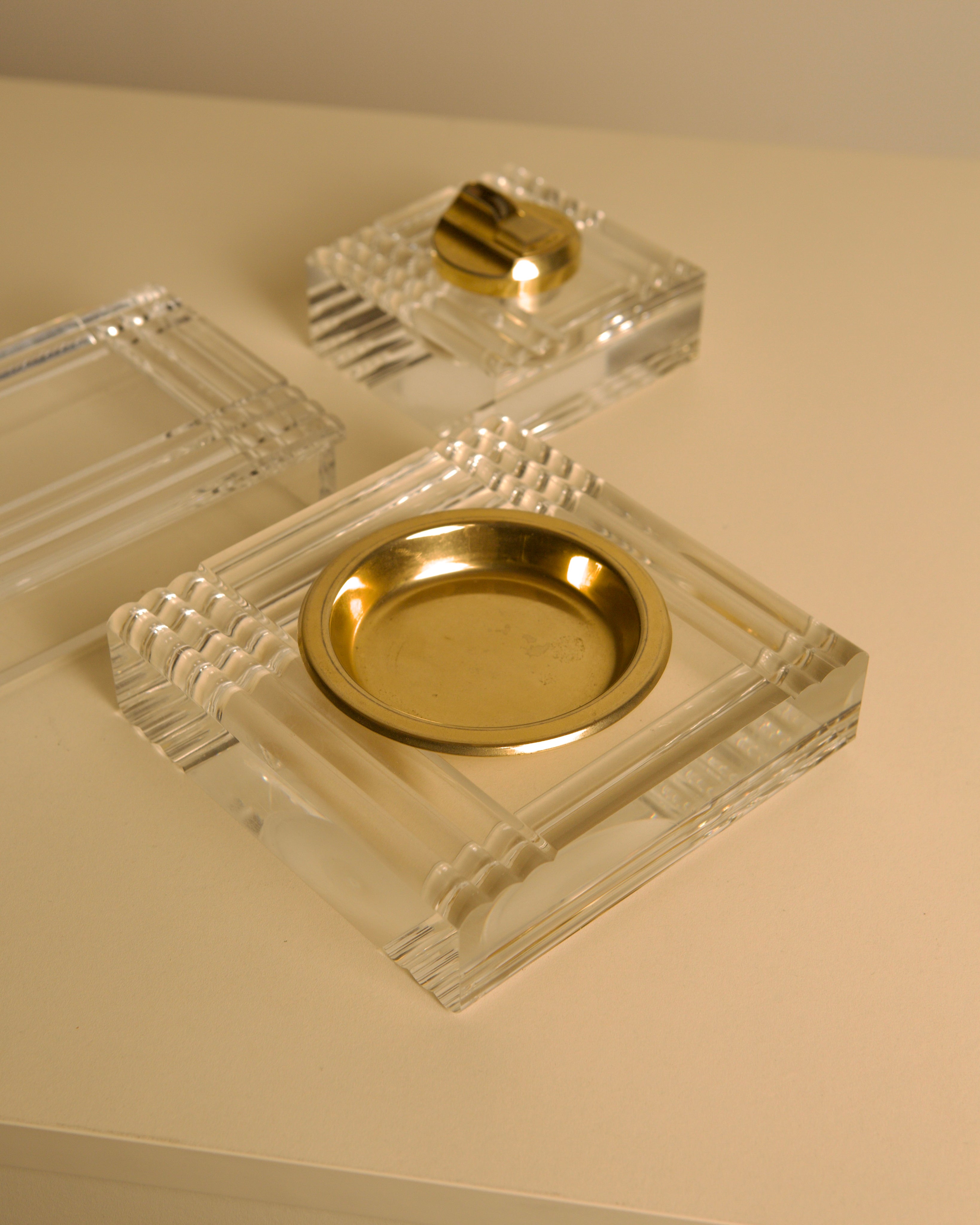 Italian Plexiglass and Brass Smoking Desk Set 70s — top view of brass ashtray on light surface