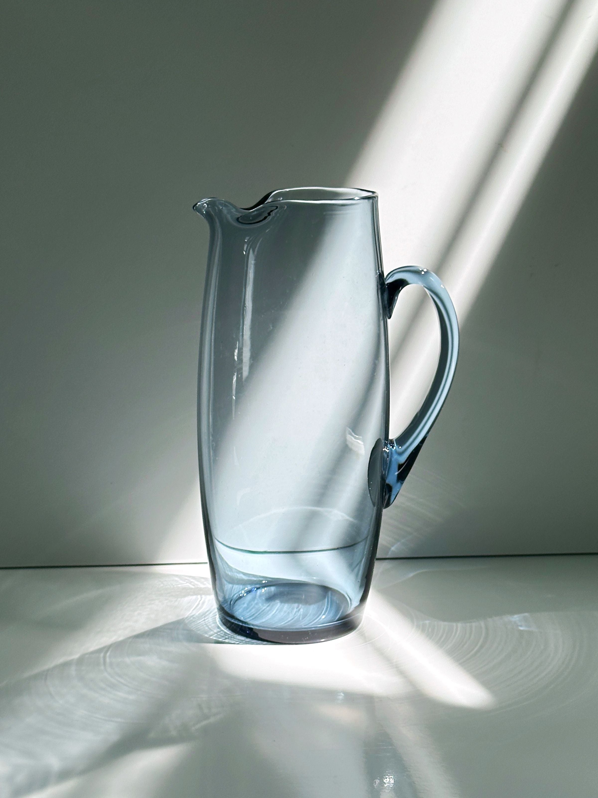Blue glass carafe with handle, elegant Scandinavian design detail