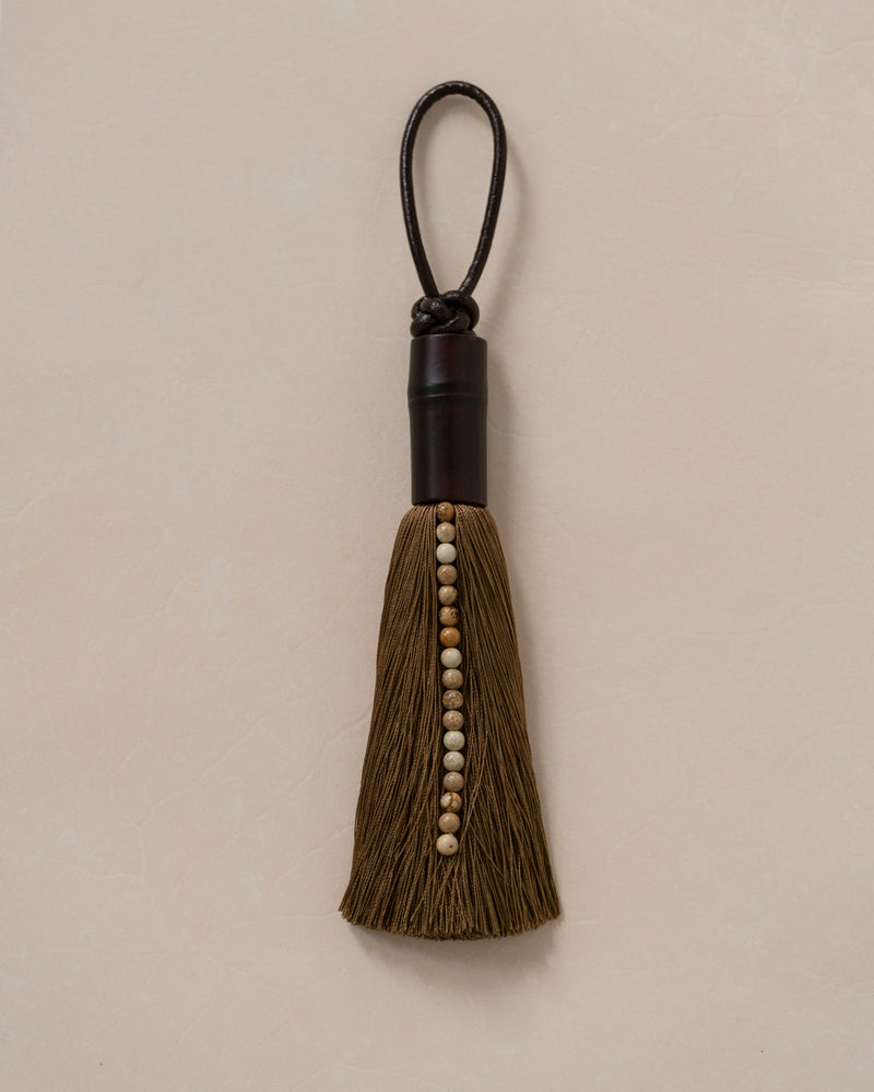 Brown tassel ornament with wooden beads and black leather loop