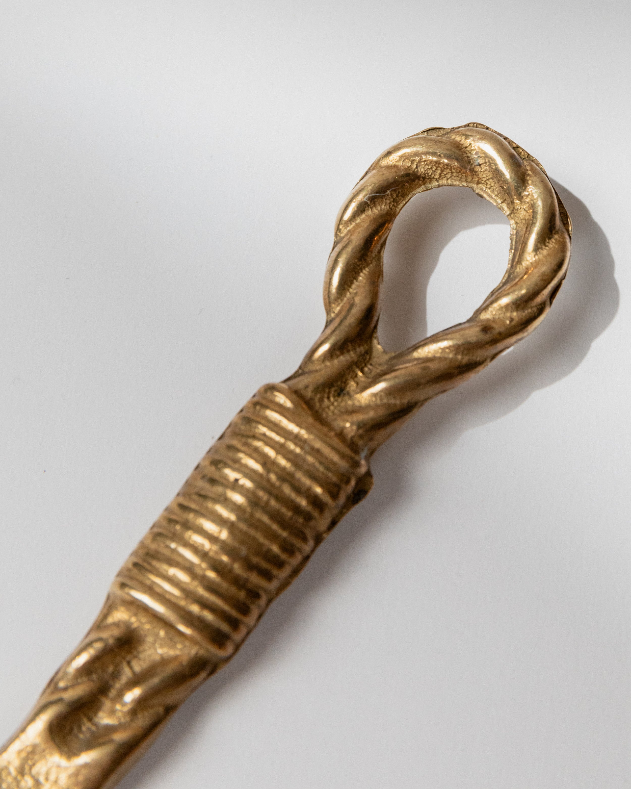 Twisted brass bottle opener handle detail showing ridged grip section