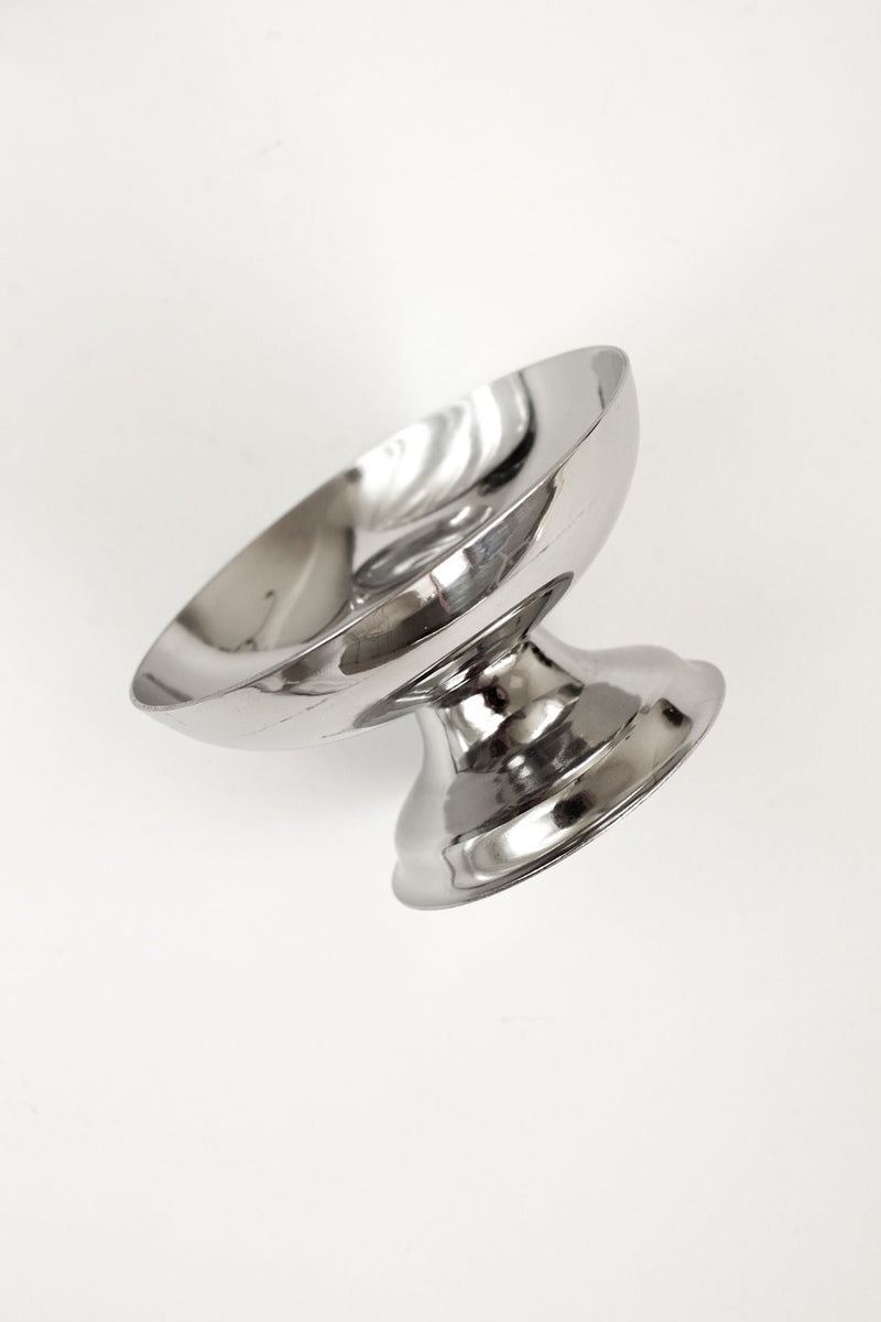 A gleaming stainless steel ice cream bowl from septembre studios’ Set of Six Ice Coupes is tilted on its side against a plain white background, evoking elegant cocktail glassware.