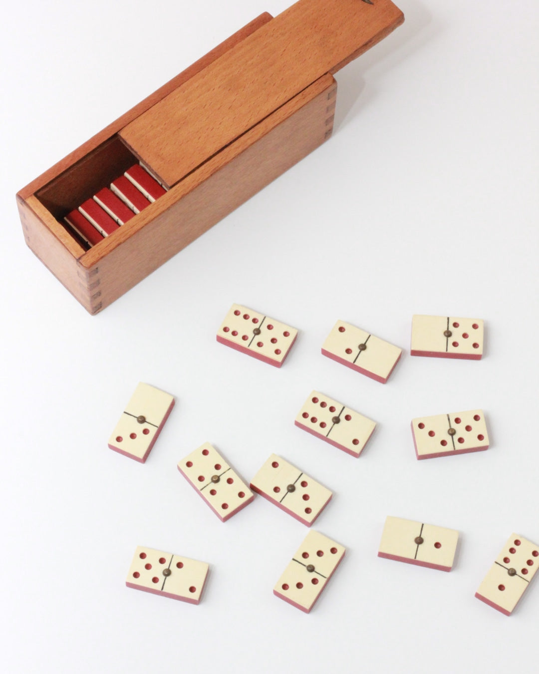 Mini Domino Set — wooden box with red and cream dominoes scattered