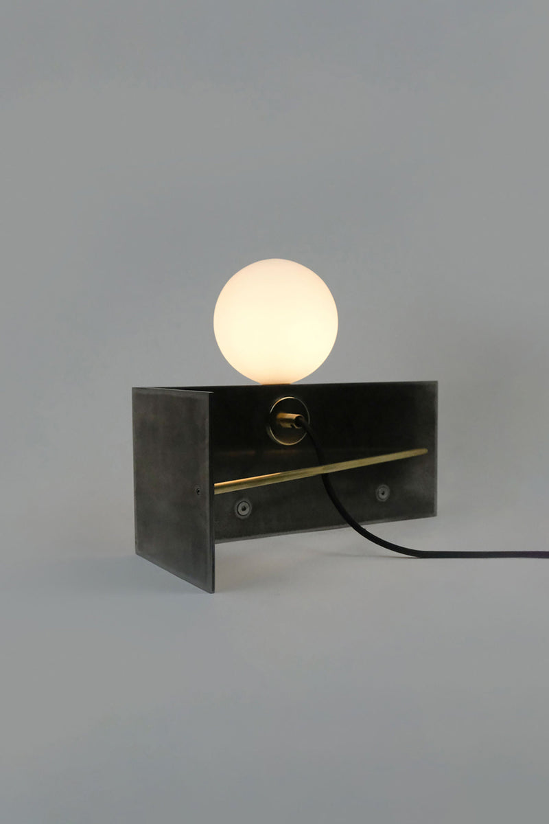 Modern black metal table lamp with glowing spherical bulb on top