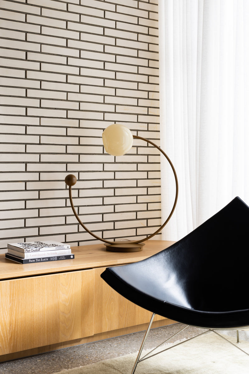 Oro Table Lamp w/ Handblown Glass — close-up of brass base on wooden console