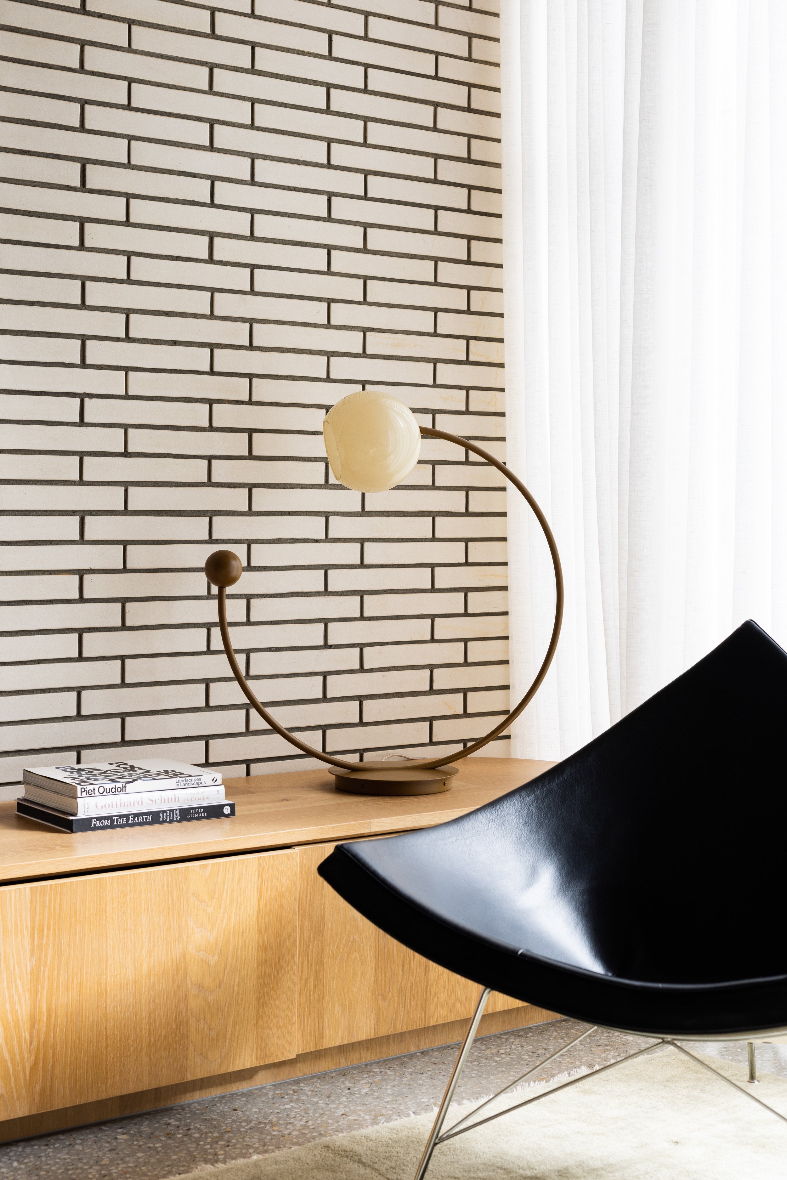 Oro Table Lamp w/ Handblown Glass — close-up of brass base on wooden console