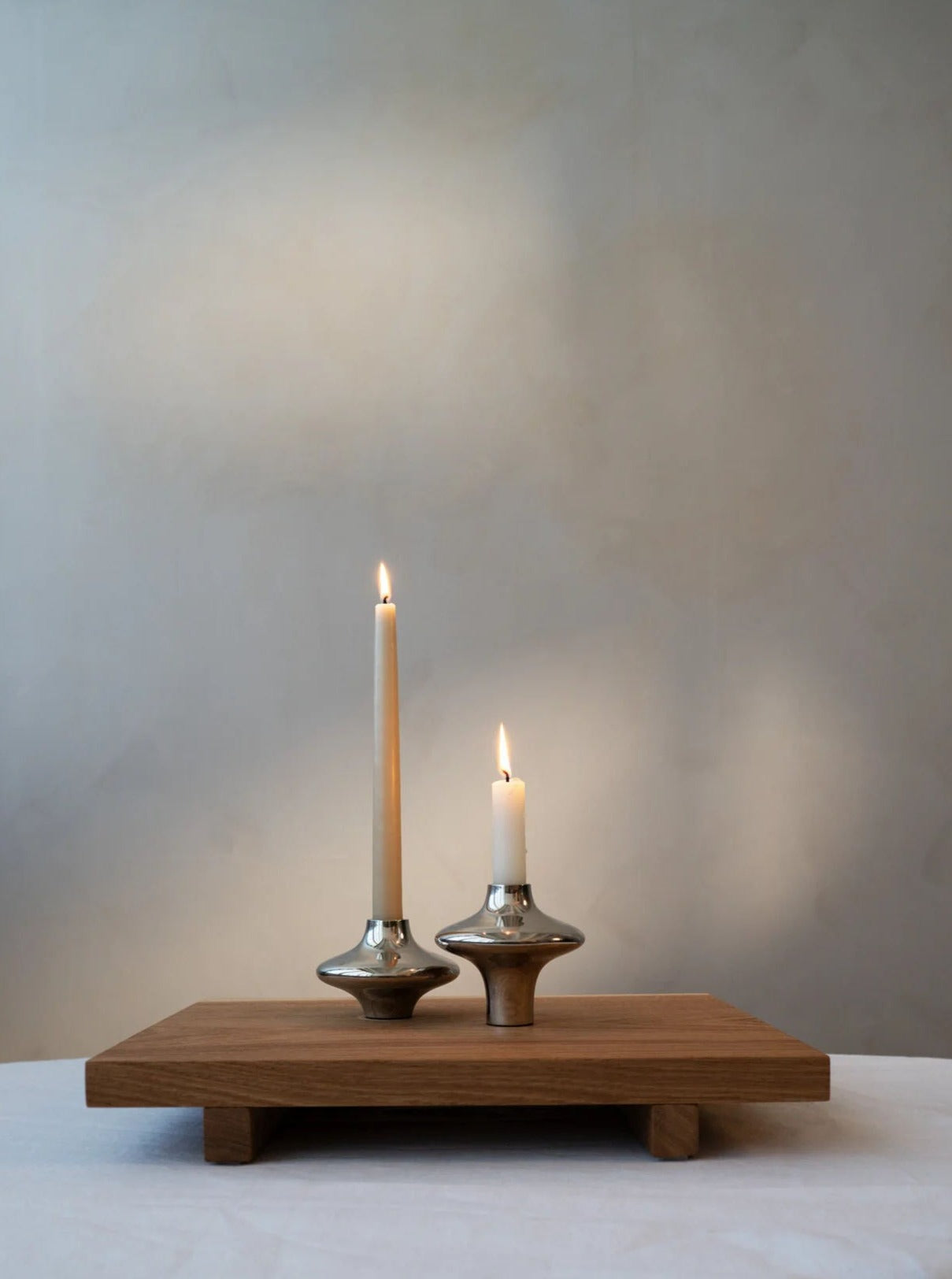 Doublet Candleholder - Large - Silver — side angle on wooden tray with candles