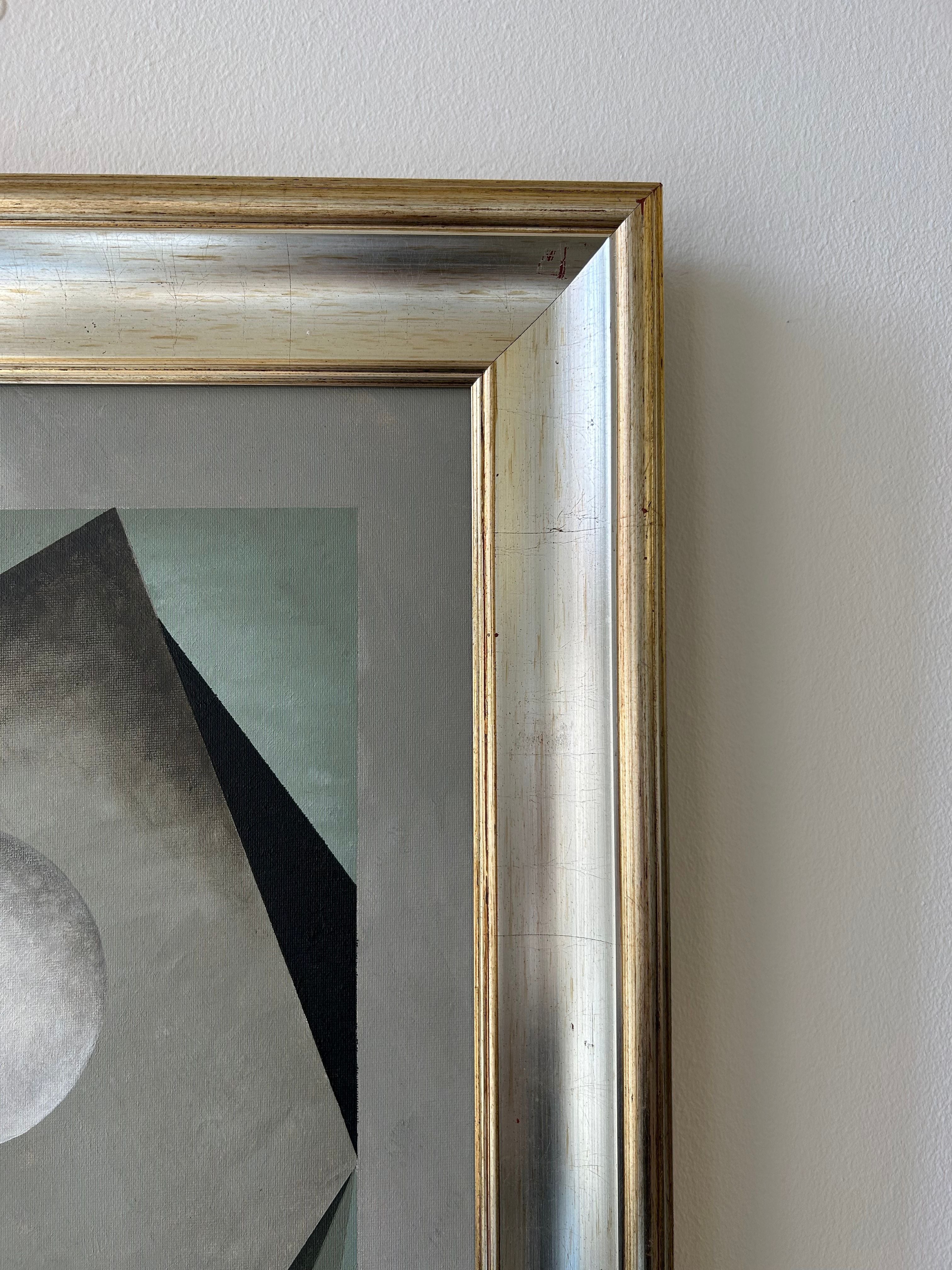 Close-up of the "Nest" painting by Iris Bavelaar: a contemporary classic in a metallic silver frame, showcasing abstract geometric forms with forest green, gray, and black accents on a white wall.
