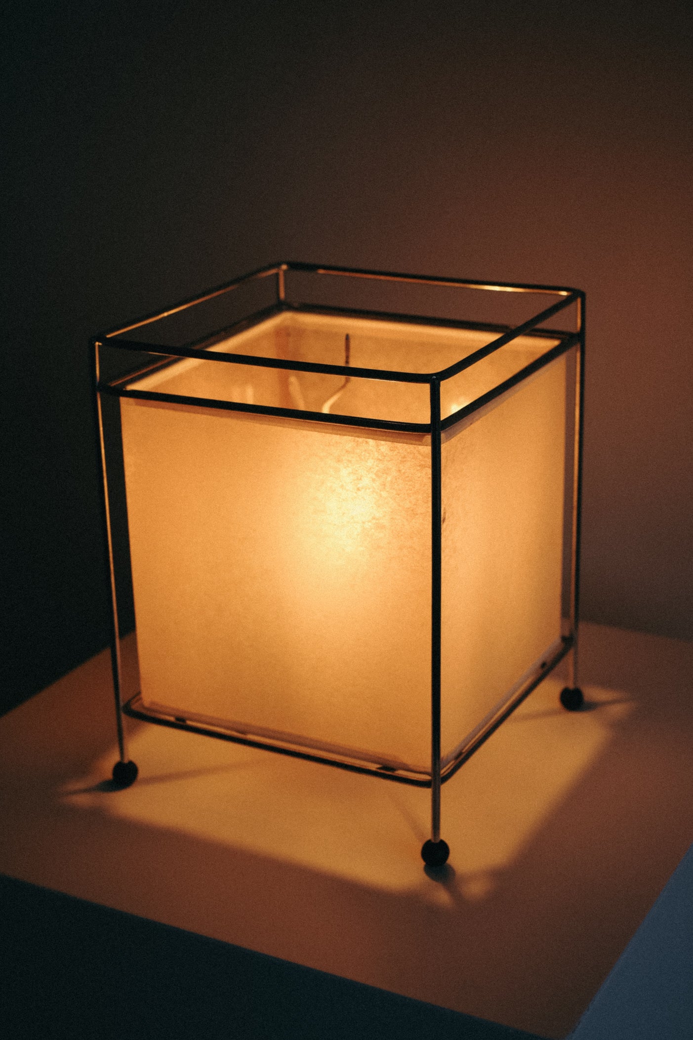 Japanese Rice Paper Table Lamp — back view with warm glow and metal frame