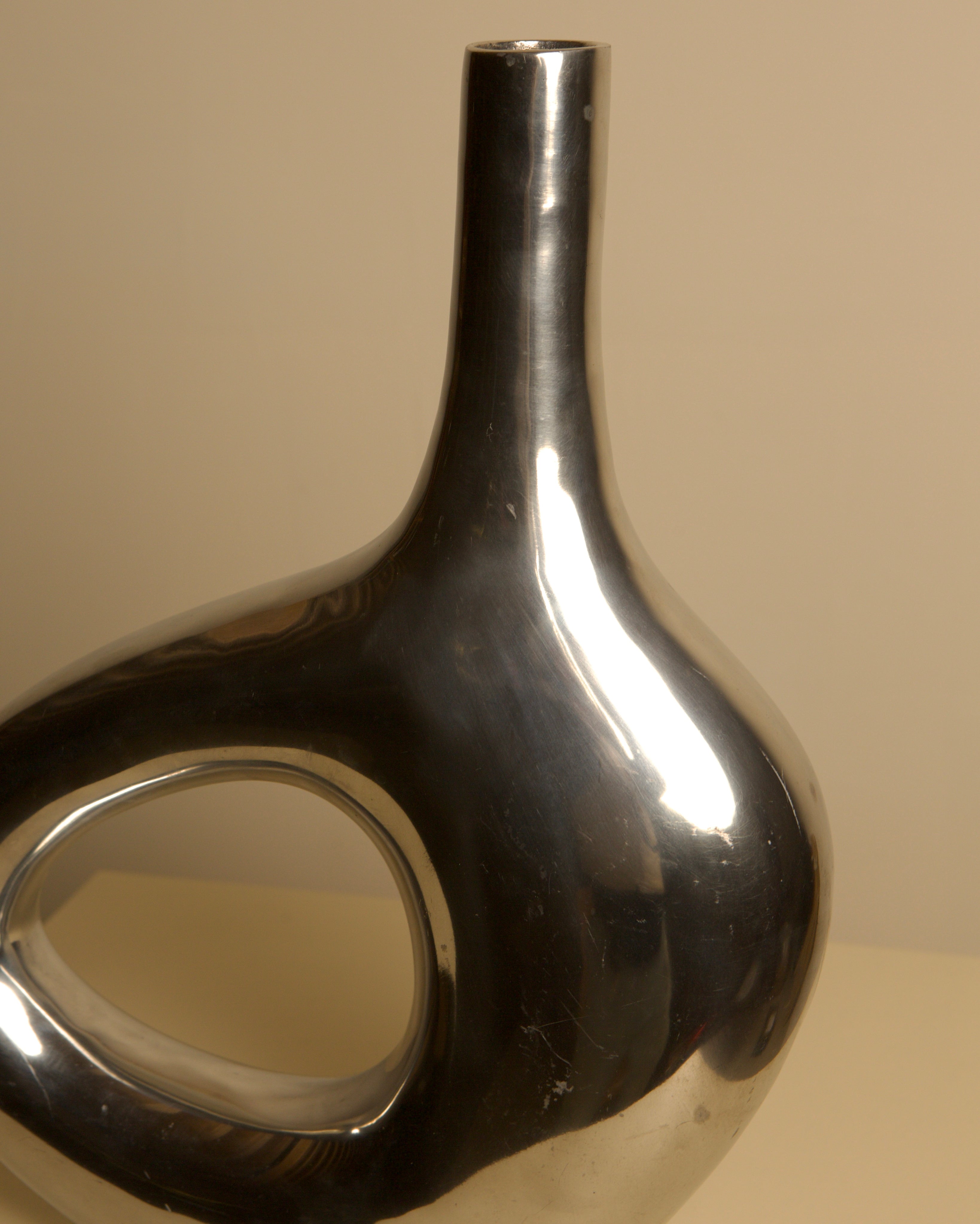 Large Italian cast aluminum vase from the 80s — side angle highlighting reflective surface