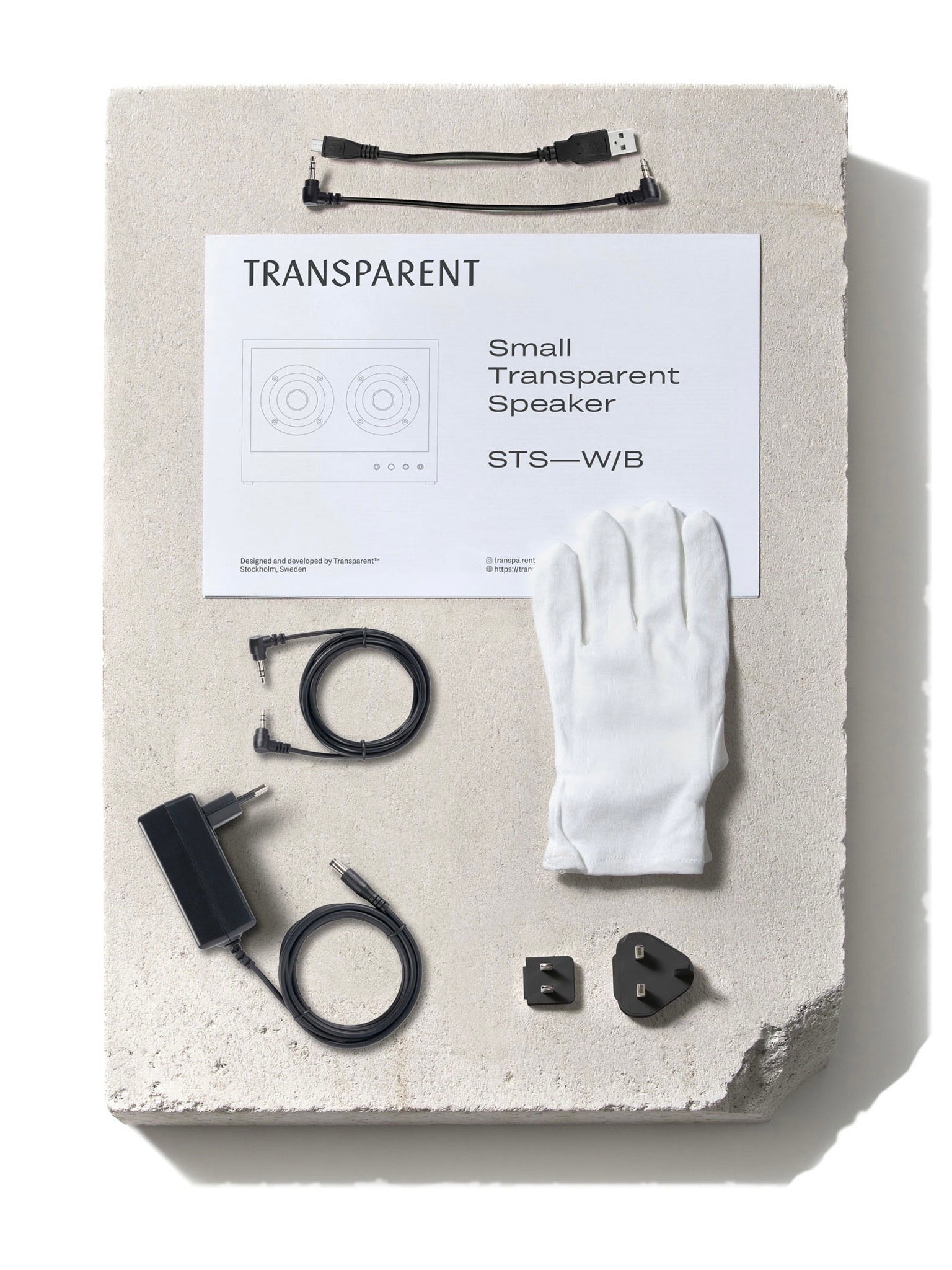 Small Transparent Speaker Black - Bluetooth — top view with accessories on stone surface