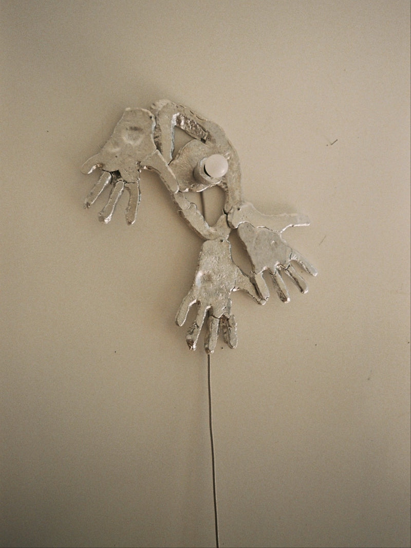 Sculptural ceramic wall lamp with hand-shaped forms by Ia Kutateladze
