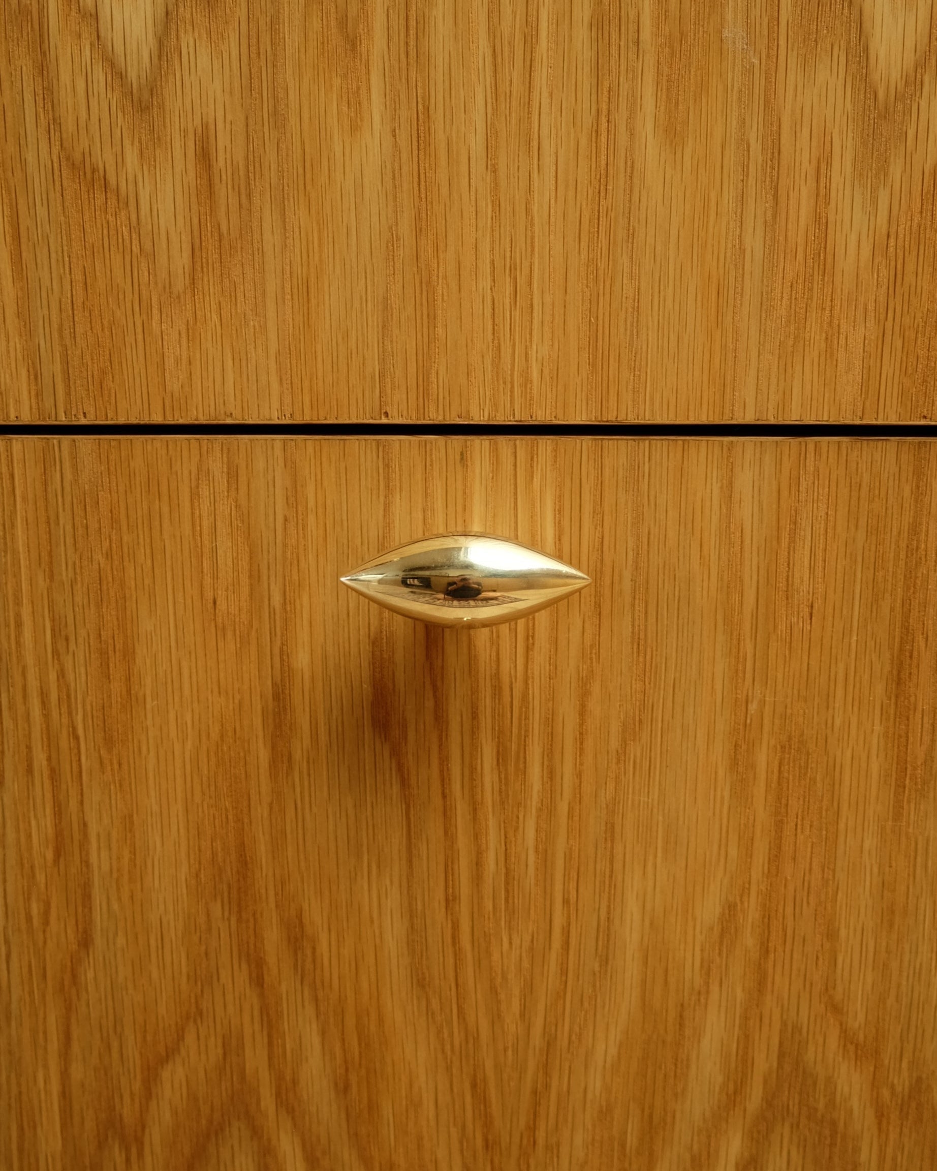 GOOD EYE Cabinet Knob/Wall Hook — close-up of polished brass knob on wood drawer