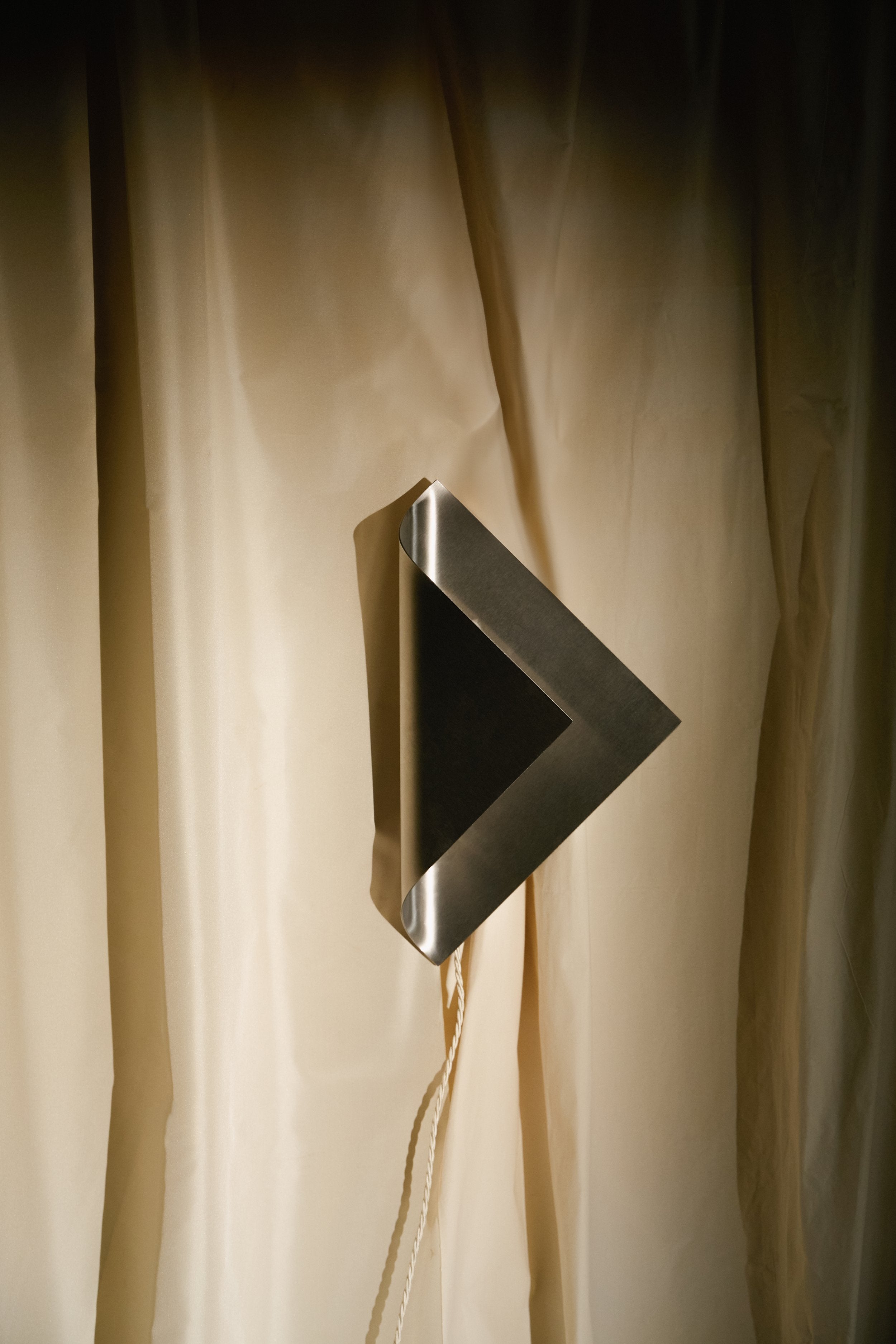 The Ferro Wall Lamp — close-up of metal shade against fabric backdrop
