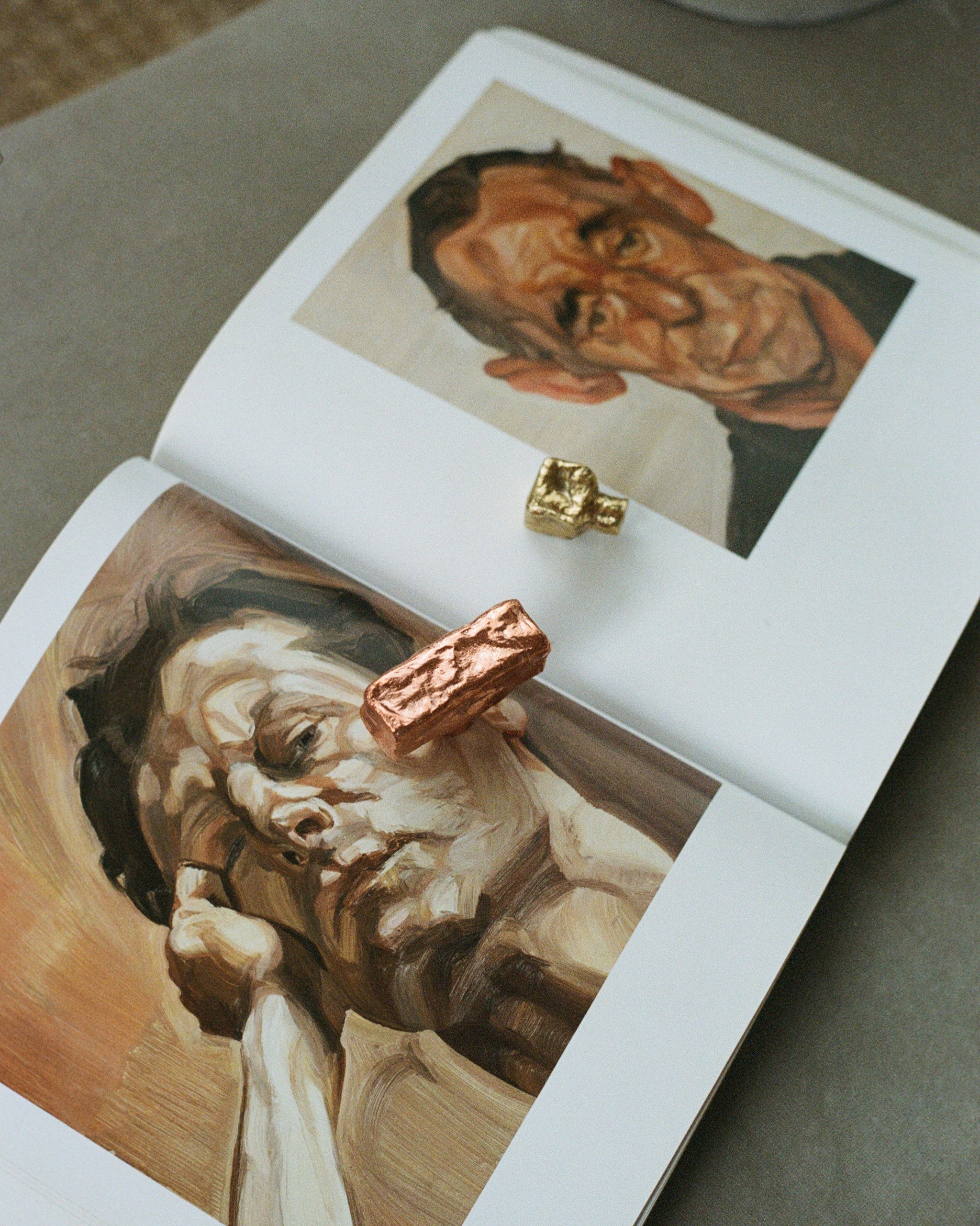 ISLE Cabinet Knob/Wall Hook Small — positioned on art book pages