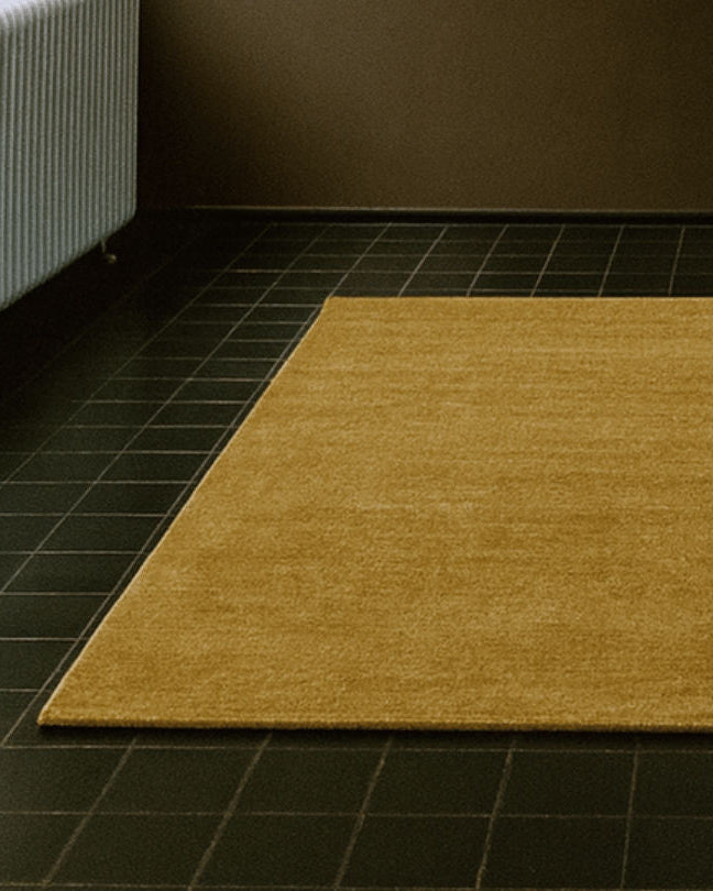 Rug 100% Wool New Zealand - Miel — angled view on dark tiled floor
