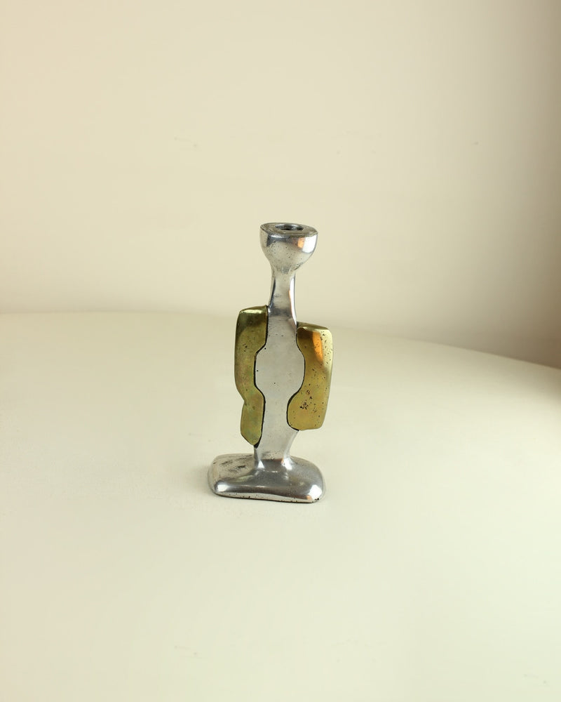 Brutalist Candleholders — close-up of polished metal with brass accents