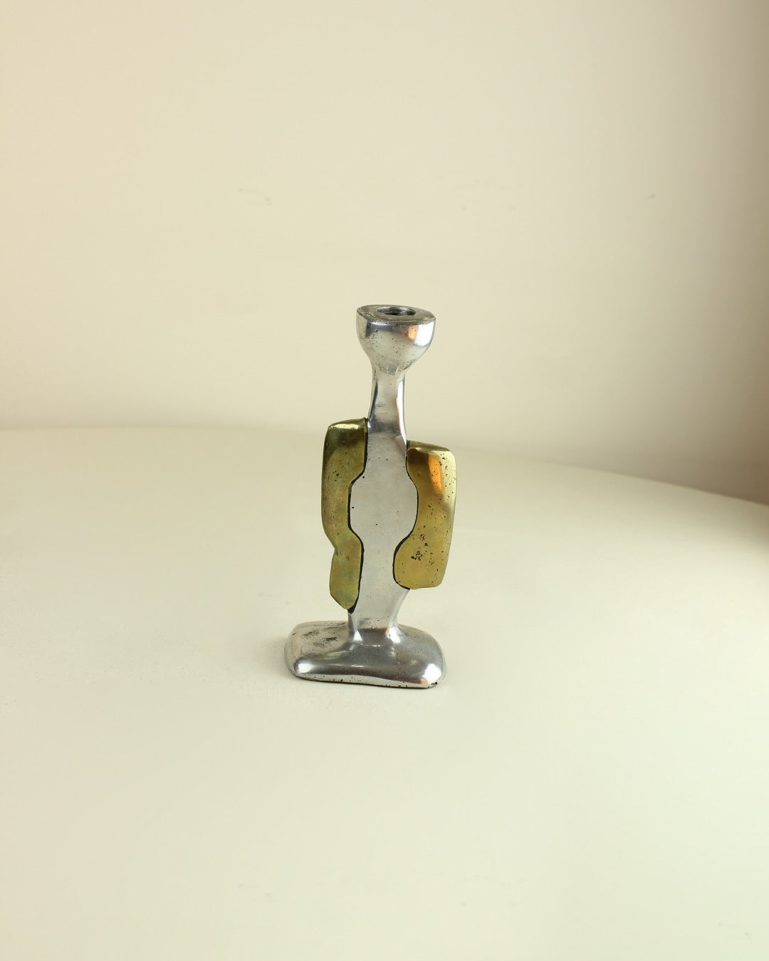 Brutalist Candleholders — close-up of polished metal with brass accents