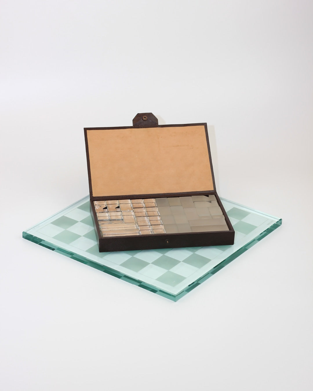 Ajedrez Minimalista — top view of glass chessboard with wooden box