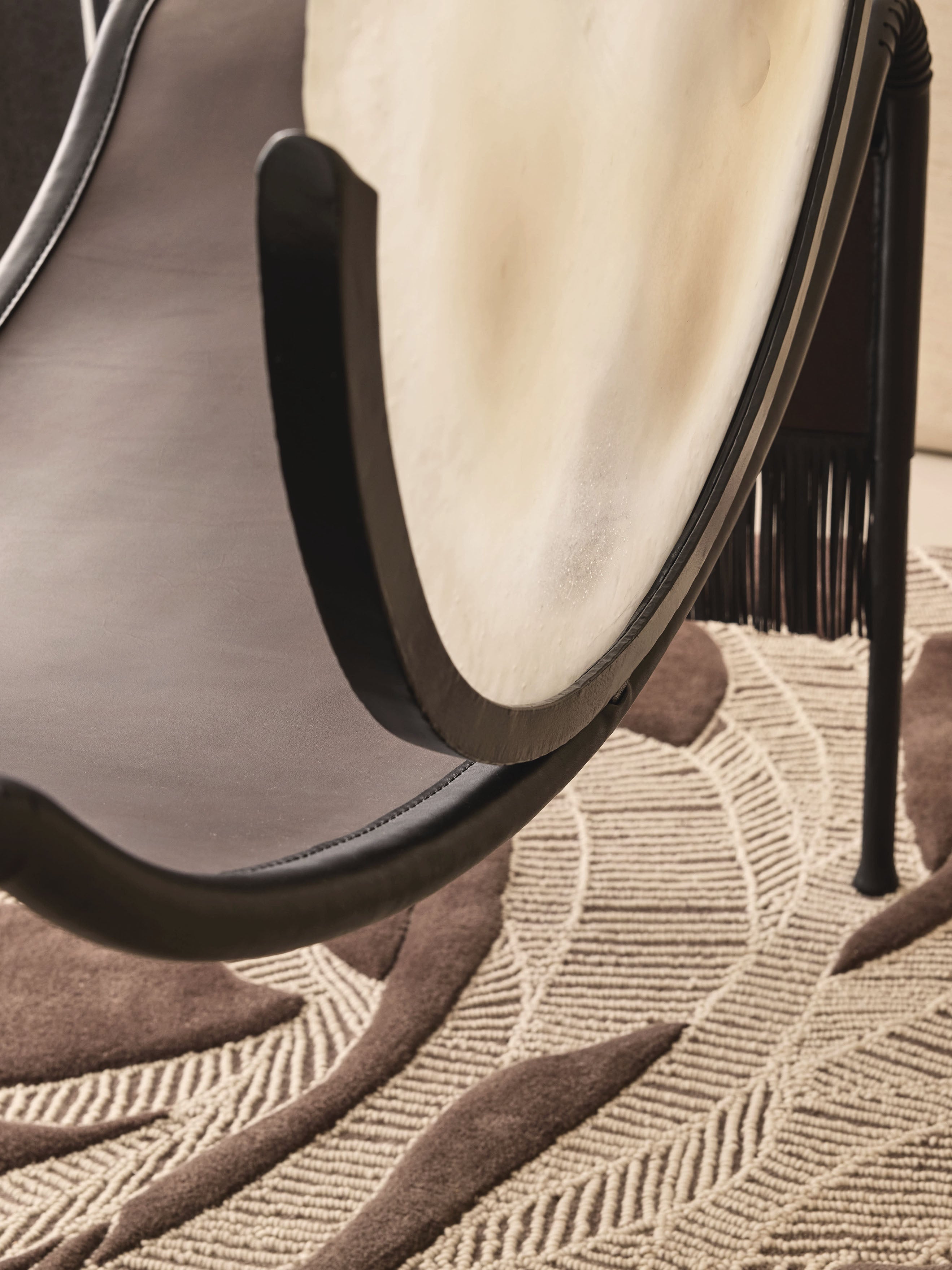 MOON Armchair in Metal and Glass — close-up of black frame on textured rug