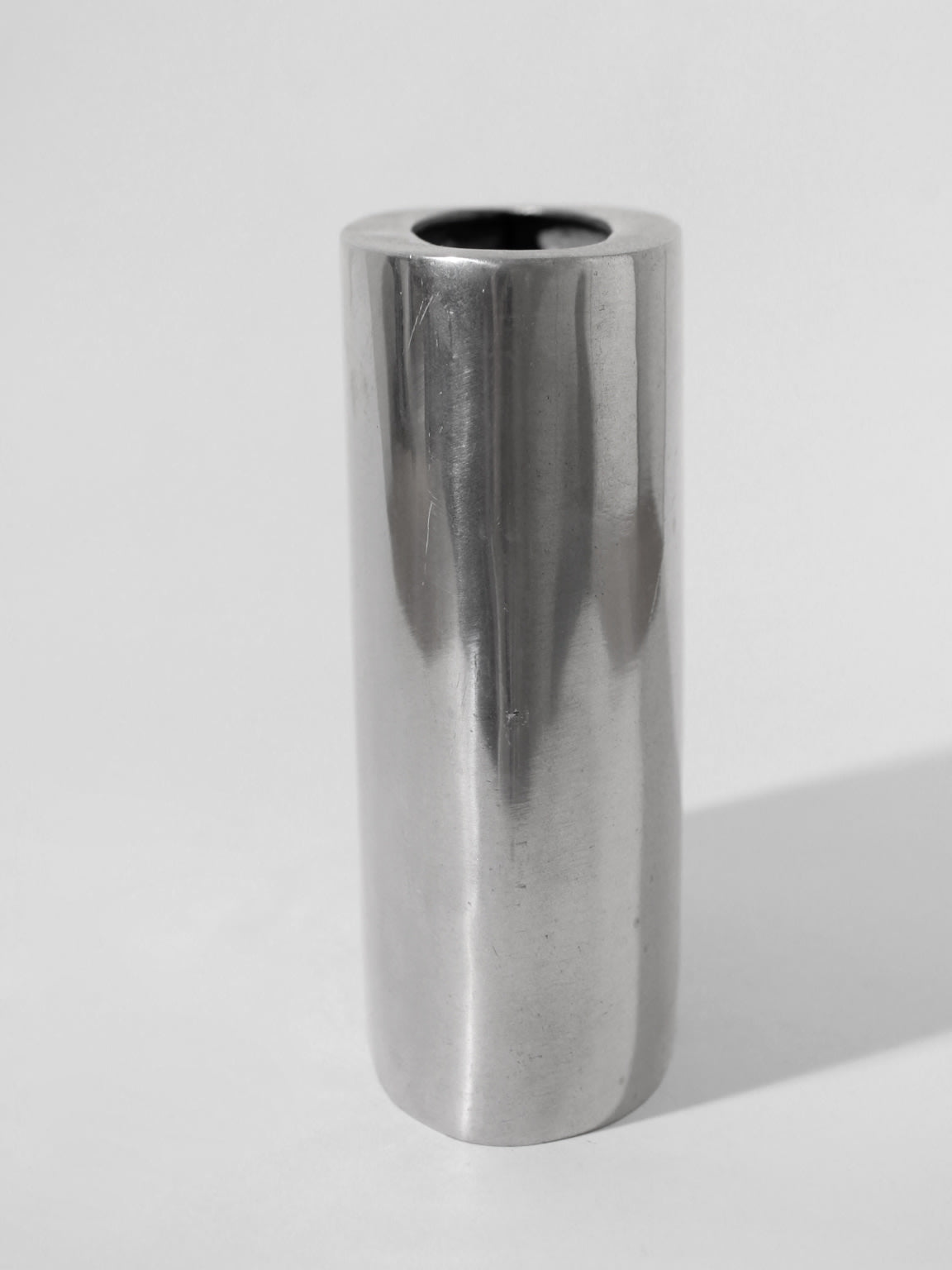 A polished, square flat aluminum vase by Vintage Stories stands upright on a light gray surface against a plain background, evoking classic 1960s decor.