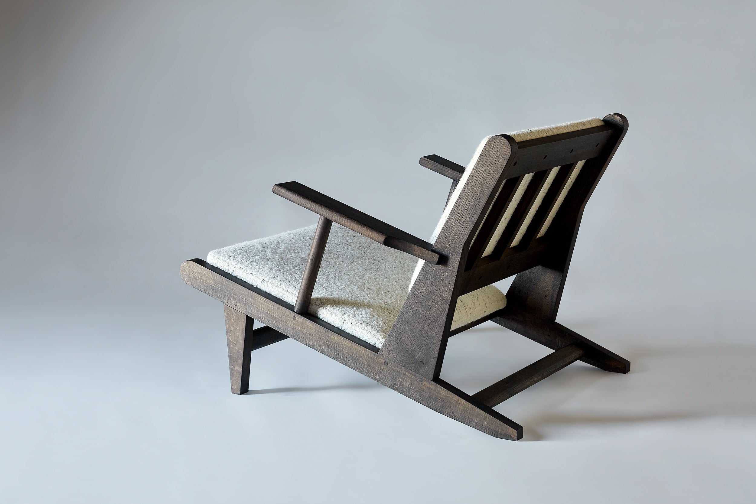Hunting Chair — side angle showing dark wood frame and light upholstery