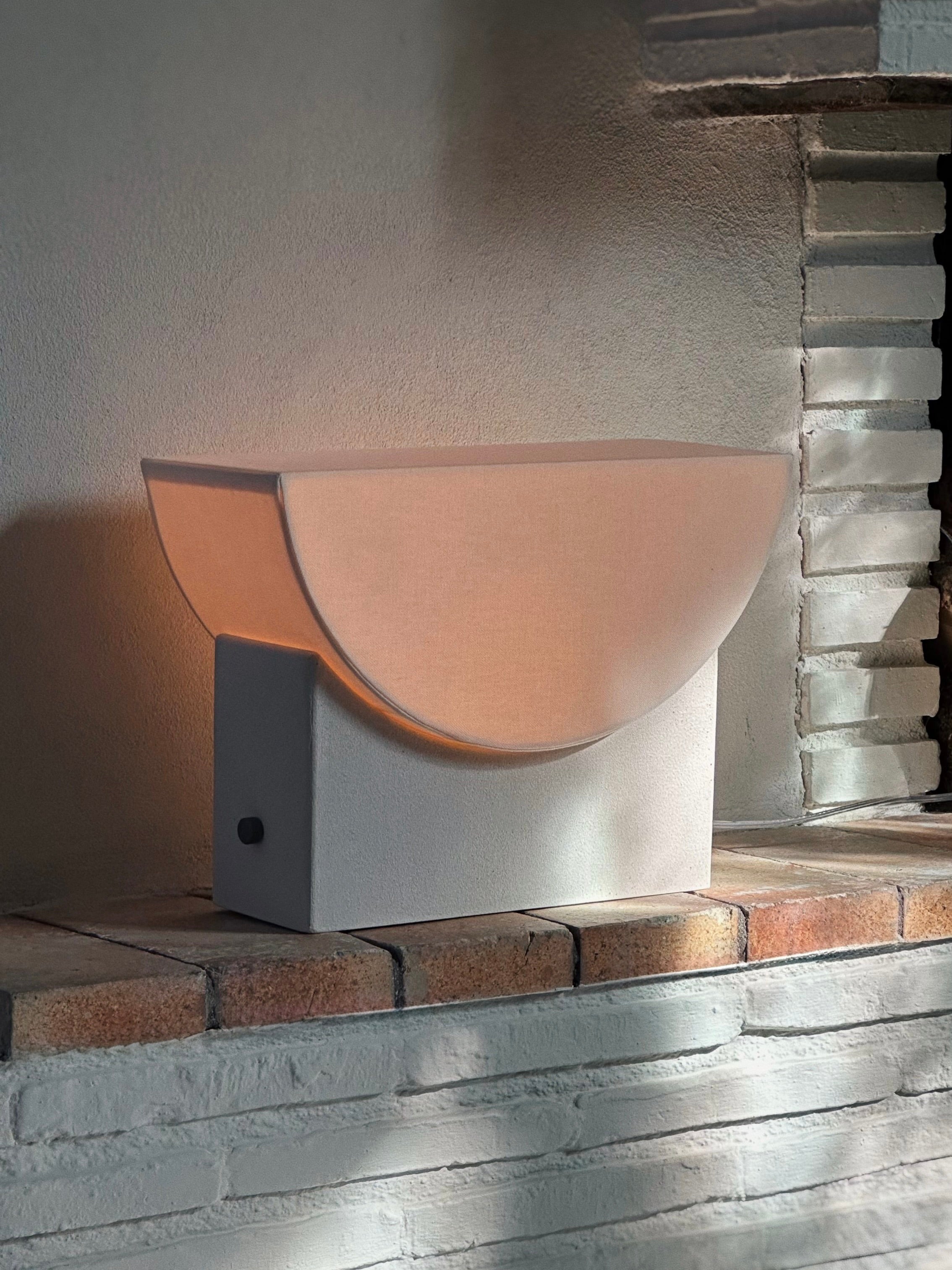 Reminder (001) – Table Lamp – Original — back view on stone ledge