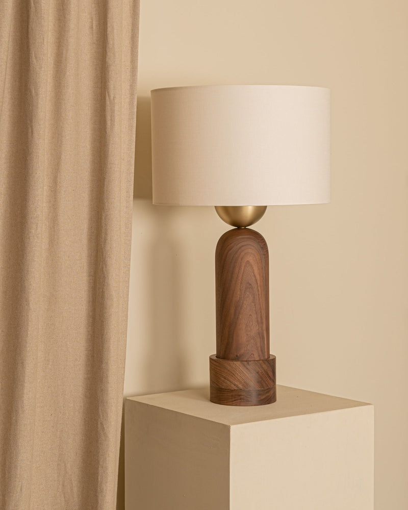 Peona Kelo walnut wood table lamp with brass accent on beige cube