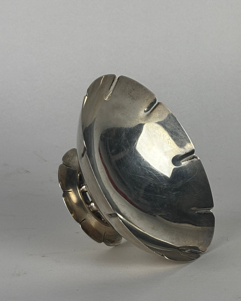 Sterling silver serving dish with curved sculptural form and polished reflective surface