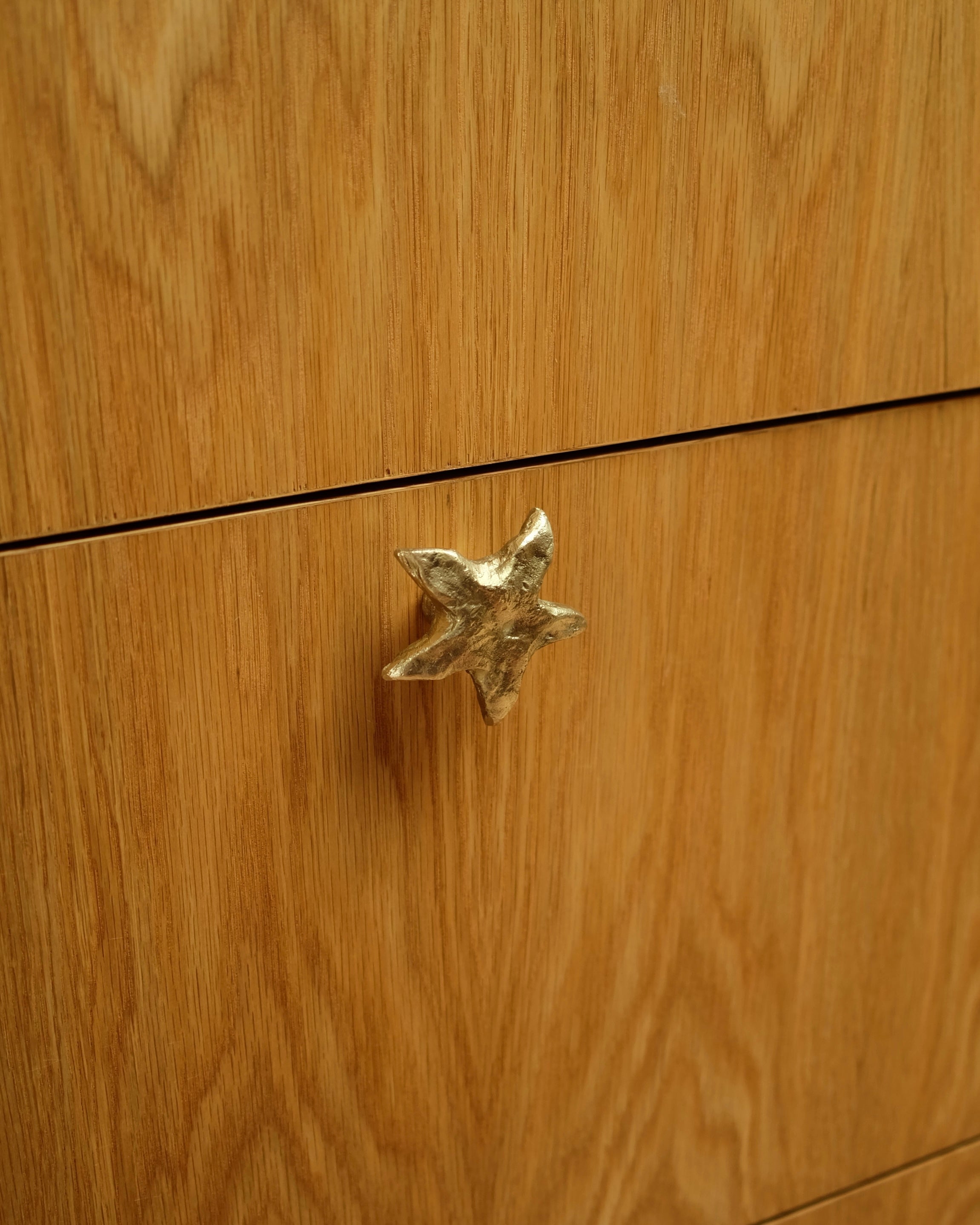 STAR Cabinet Knob/Wall Hook — close-up on gold star knob against wood drawer