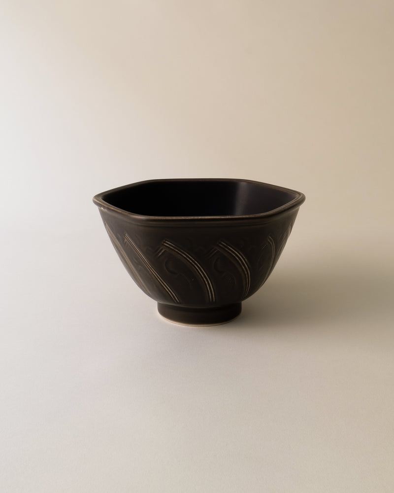 Dark ceramic bowl with carved geometric patterns by Nils Thorsson