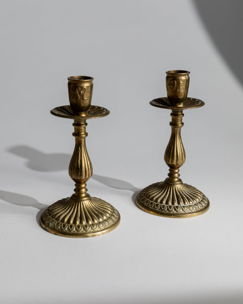 Pair of ornate brass candlesticks with detailed ribbed bases