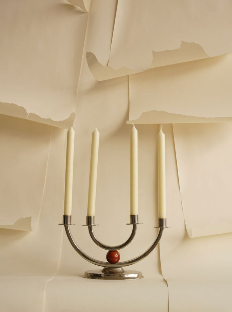 Modern brass candelabra with four cream candles and red accent