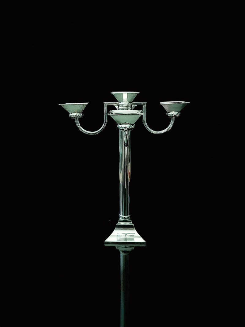 The Silver Plated Art Deco Candelholder 80s by Dodo Vintage features a reflective base and stands out elegantly against a solid black background.