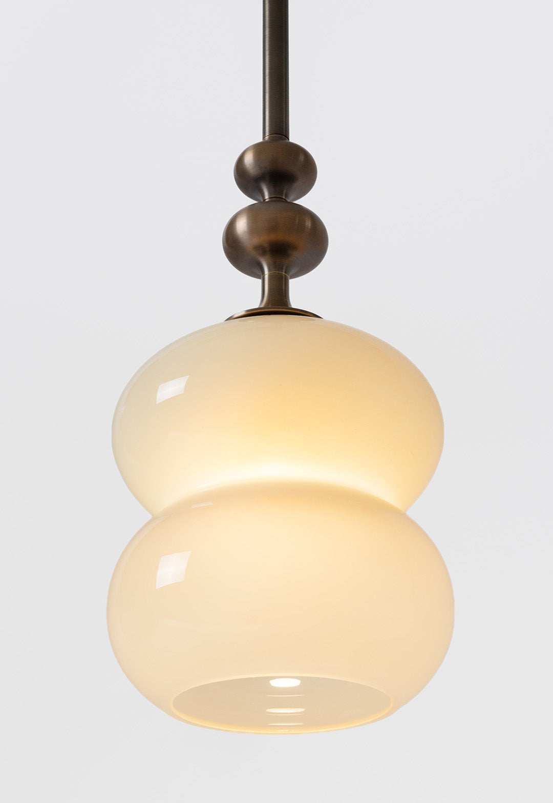 SkLO + AvroKO Oestre Pendant - Light Beige glass, Antique Brass finish — lifestyle setting